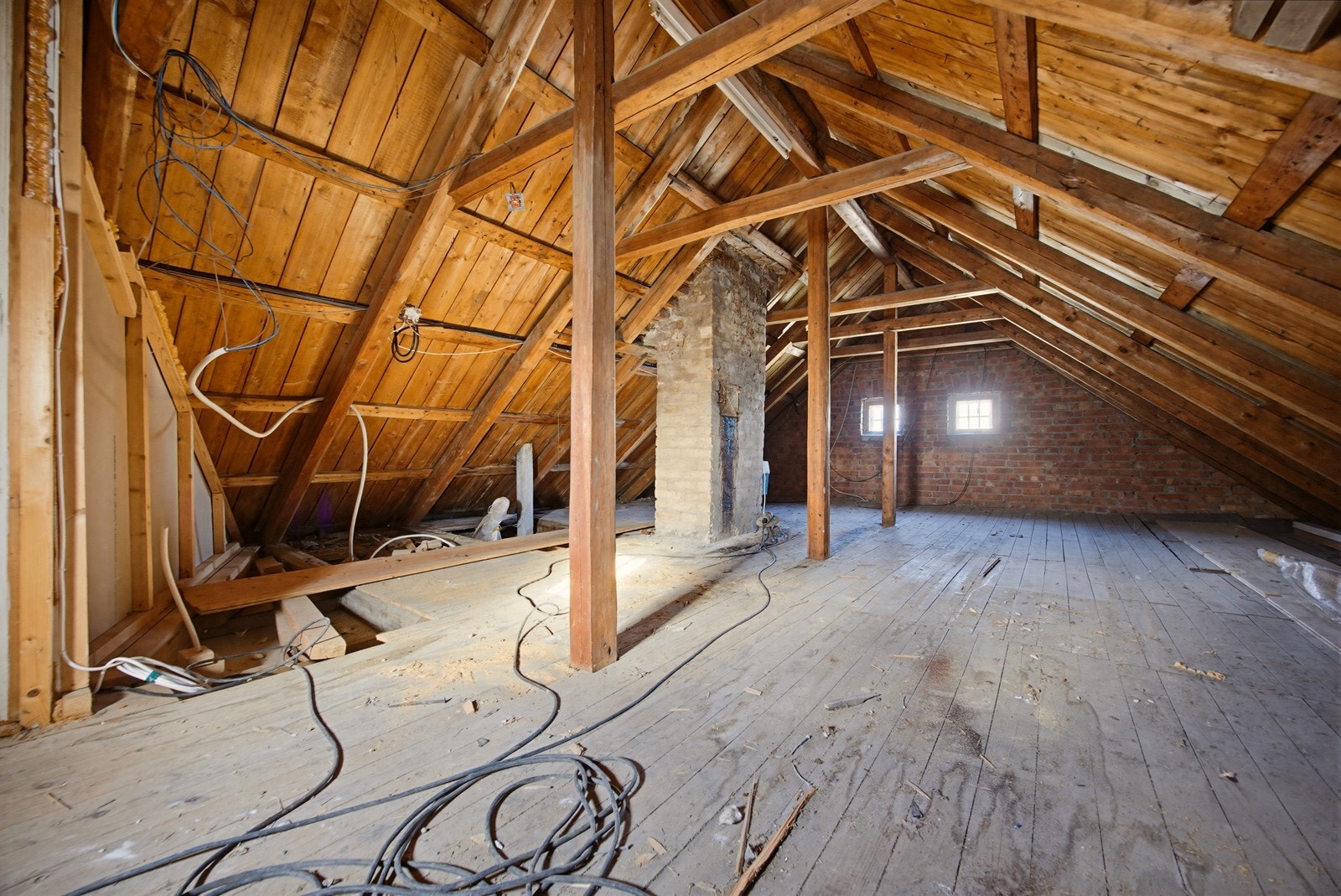 Stort, uinnredet loft med synlige takbjelker og et gulvareal på 55 m². Galleribilde