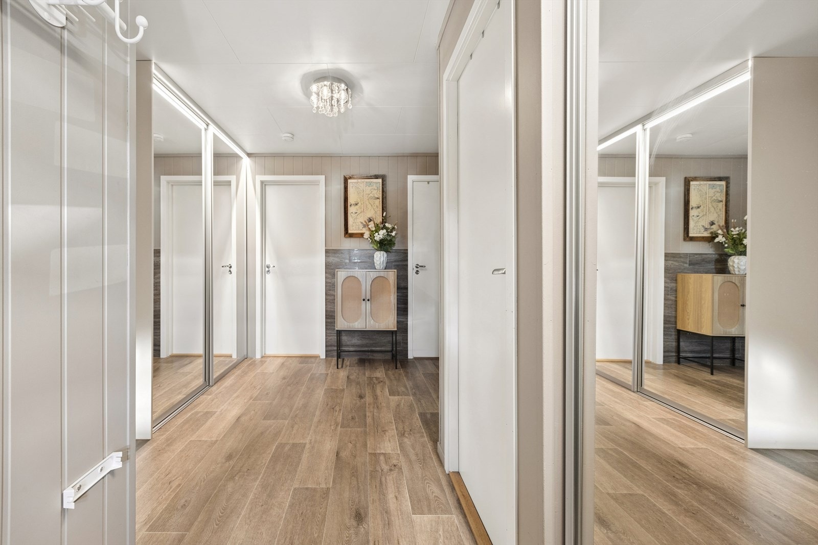 Hallen i første etasje har rikelig med oppbevaringsplass i Elfa skyvedørsgarderober med speilfronter. Galleribilde