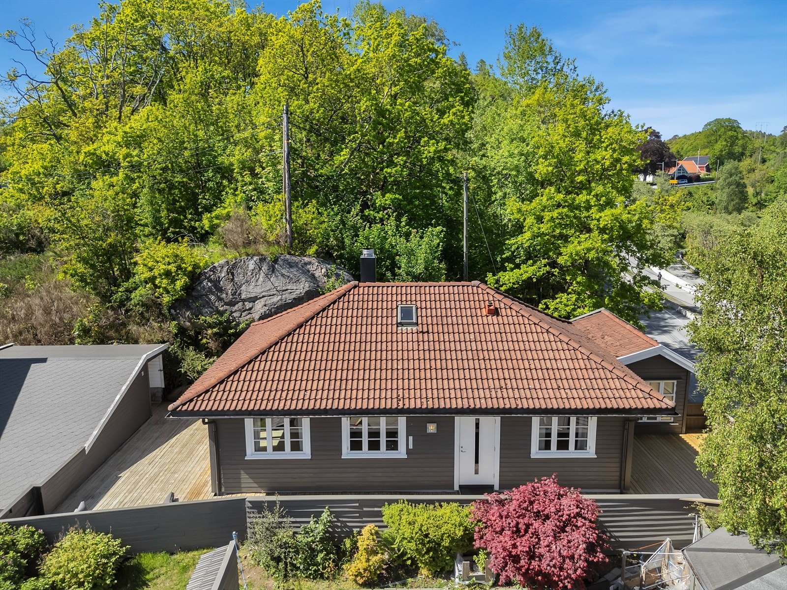 Eiendommen sett fra luften, som viser boligens plassering, uteområder og den separate garasjen. Galleribilde