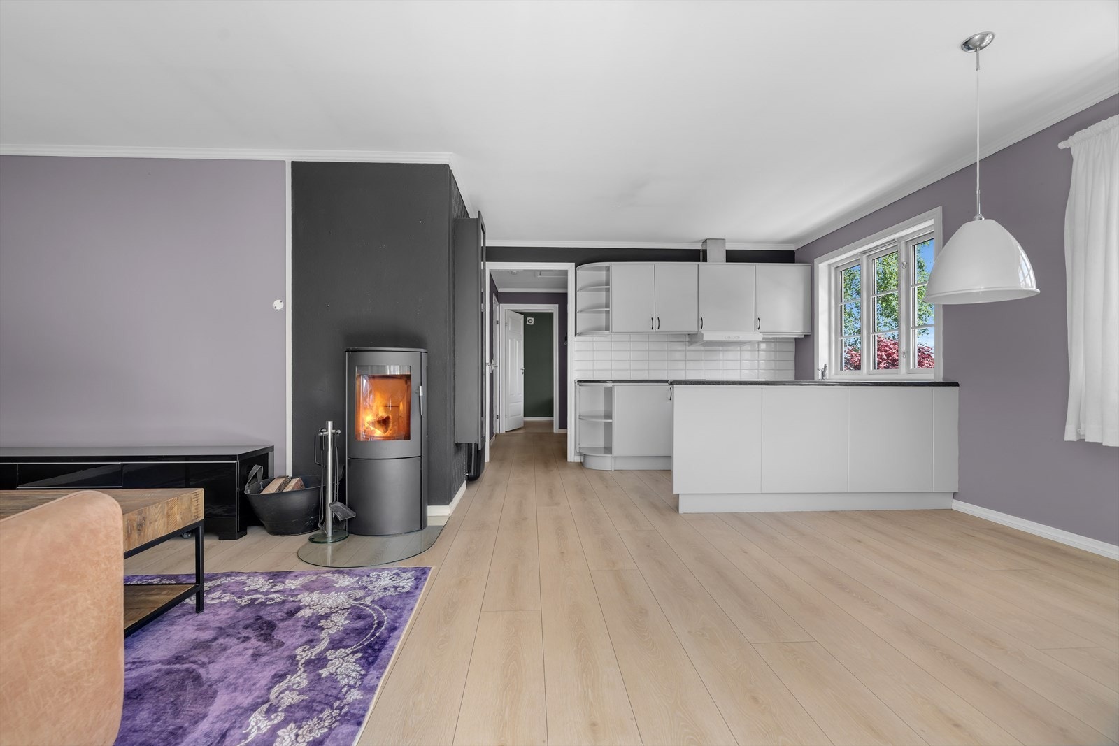 Stuen og kjøkkenet er i en åpen løsning. En vedovn, koblet til elementpipe, gir både varme og hygge. Galleribilde