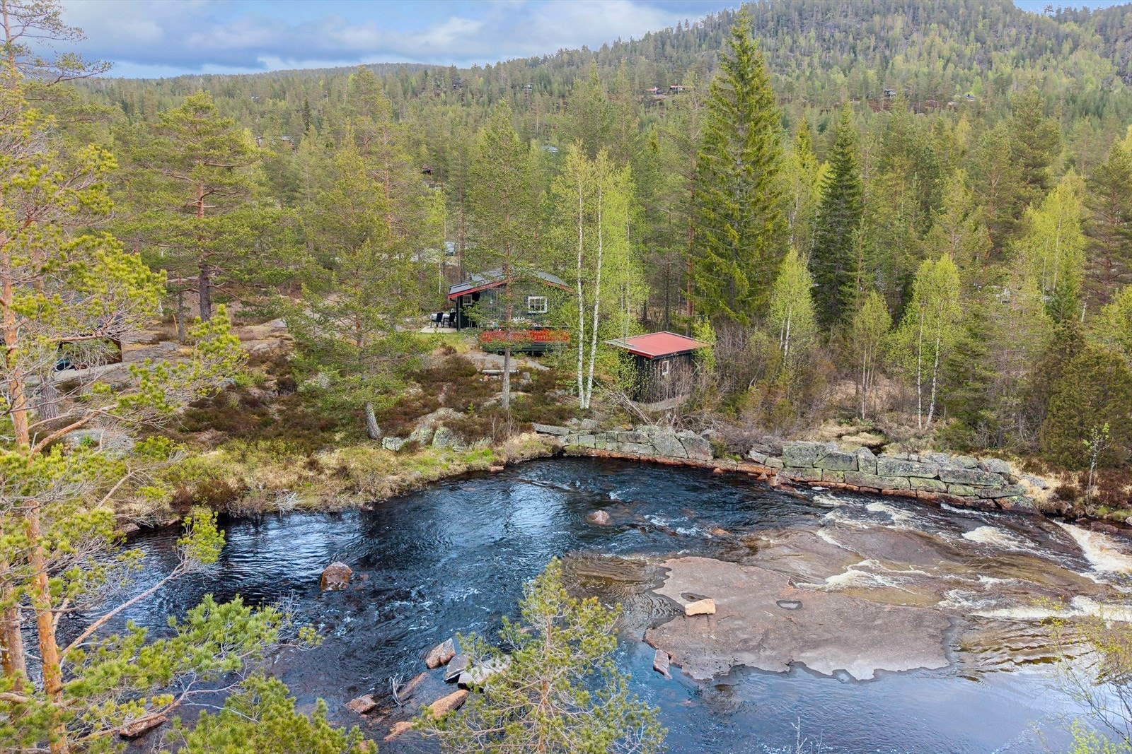 Hytta ligger usjenert til i et skogsområde, med kort avstand til vannet. Galleribilde