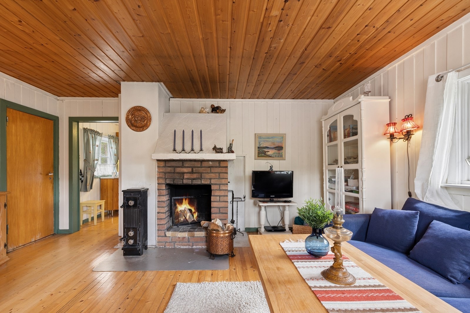 Stuens midtpunkt er en murt peis og en vedovn som sørger for varme og hygge. Galleribilde