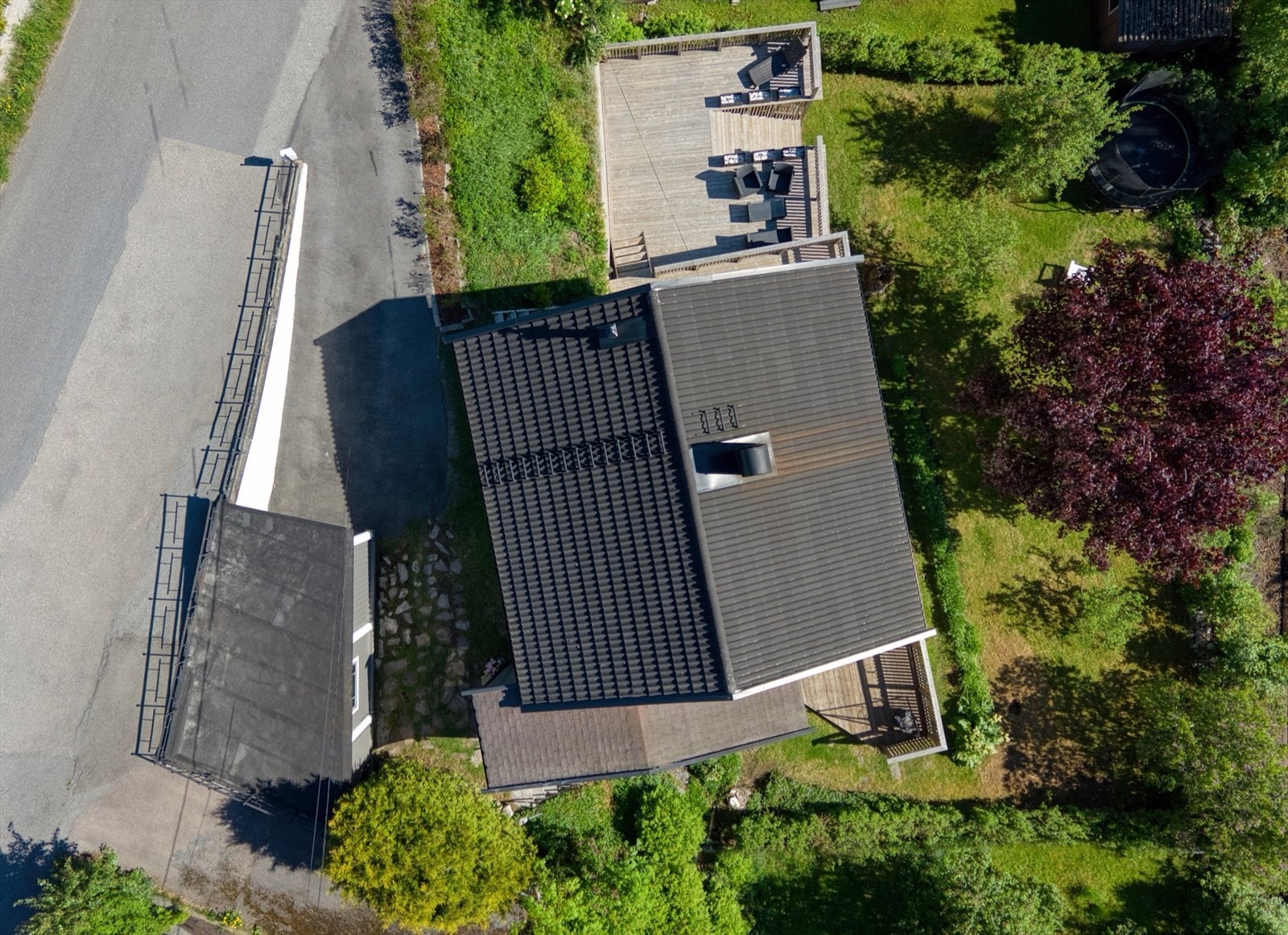 Eiendommen avbildet fra fugleperspektiv. Godt med ekstra parkeringsmuligheter langs gjerdet ved innkjøringen til eiendommen. Galleribilde