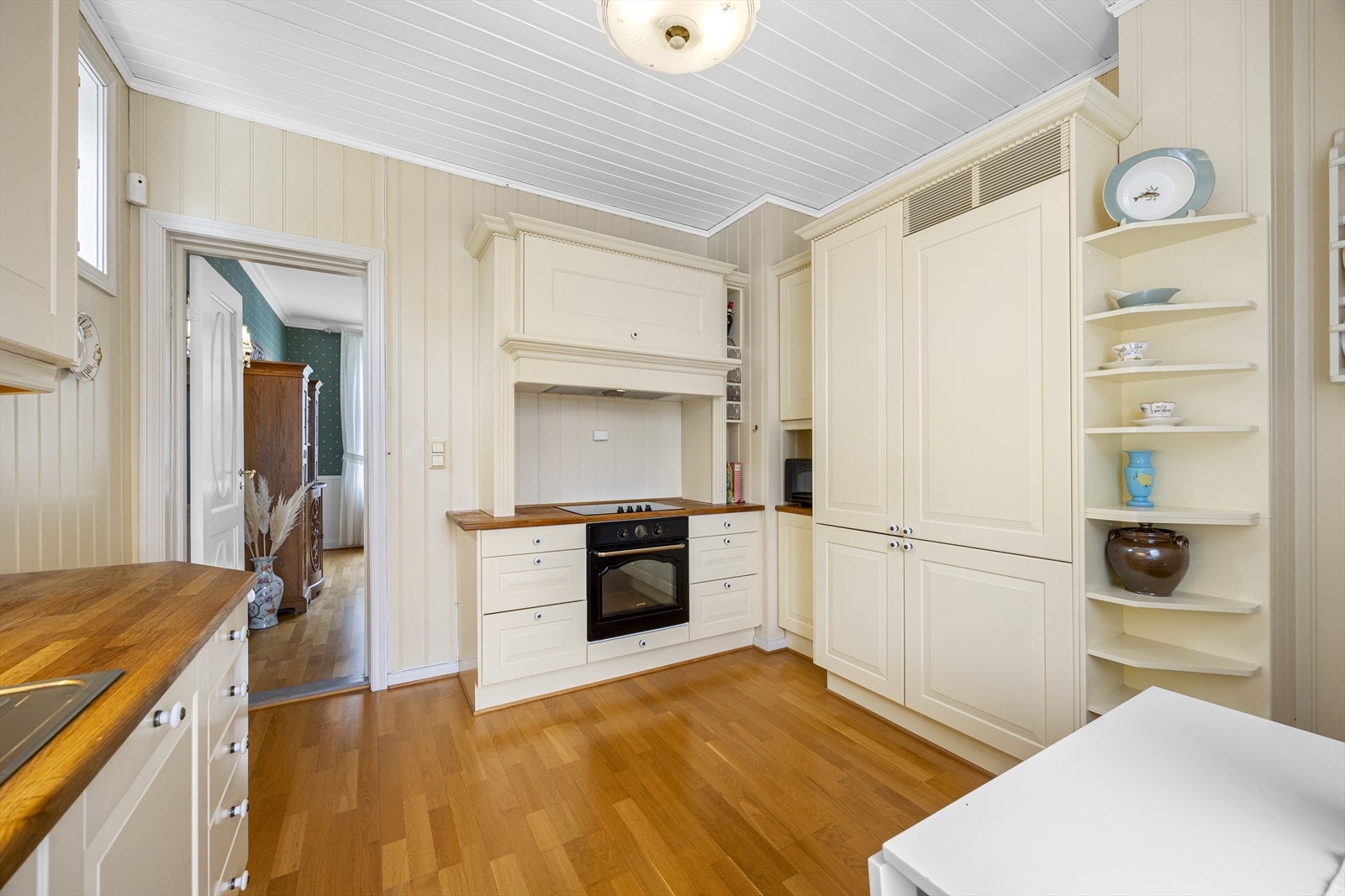 Kjøkkenet har romslig innredning fra Sigdal, type Herregård med malte, profilerte fronter, innebygget komfyr og keramisk topp samt ventilator. Galleribilde