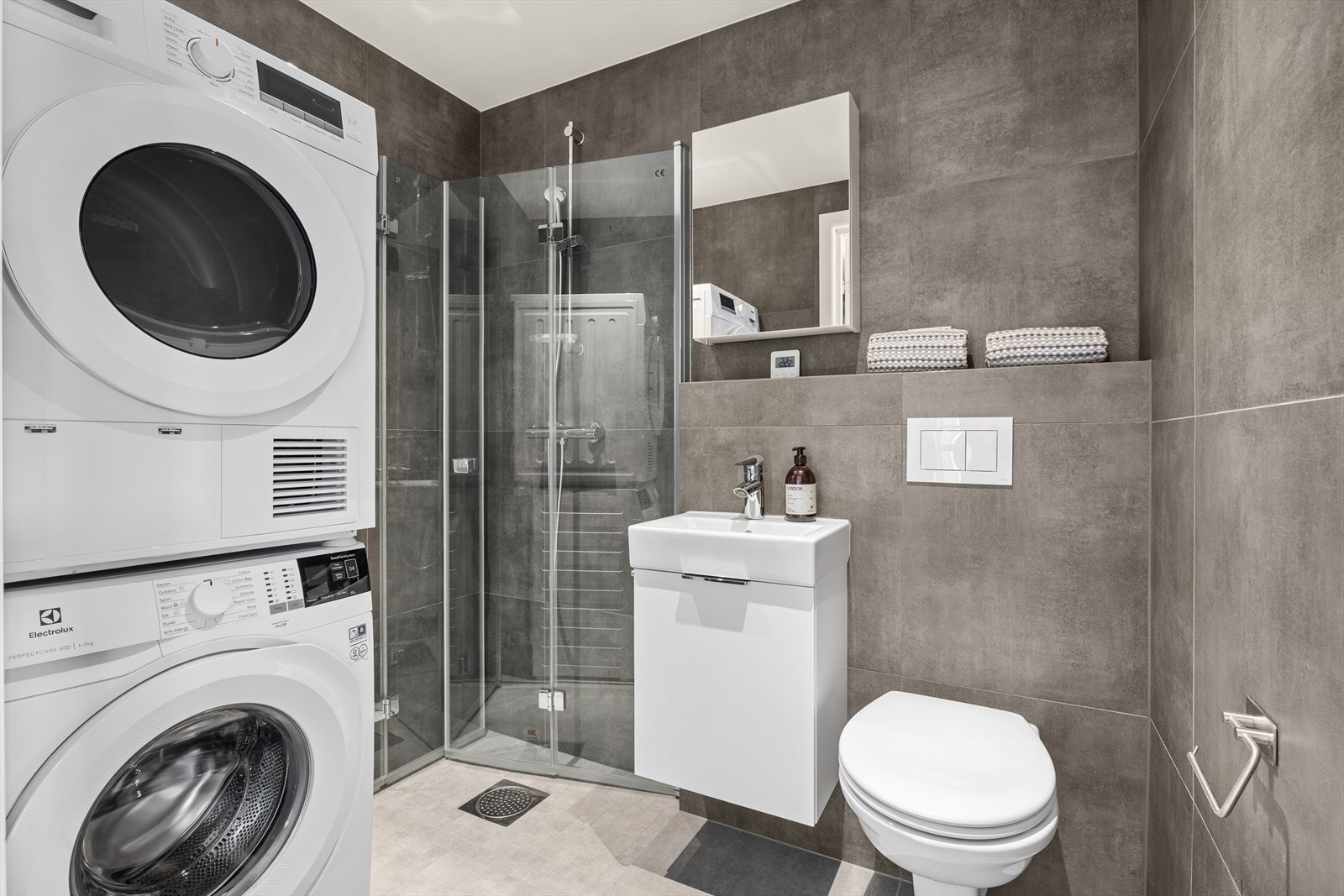 Badet i 1. etasje er kombinert vaskerom med opplegg for vaskemaskin. Rommet har fliser og vannbåren gulvvarme. Galleribilde