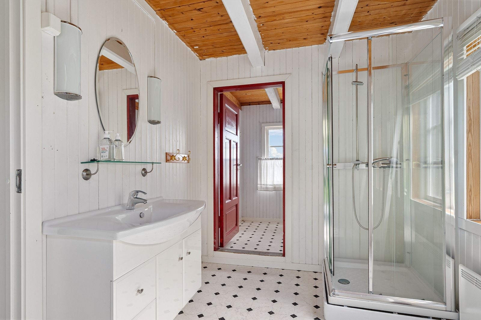 Badet er utstyrt med dusjkabinett, servant og muldo. Galleribilde