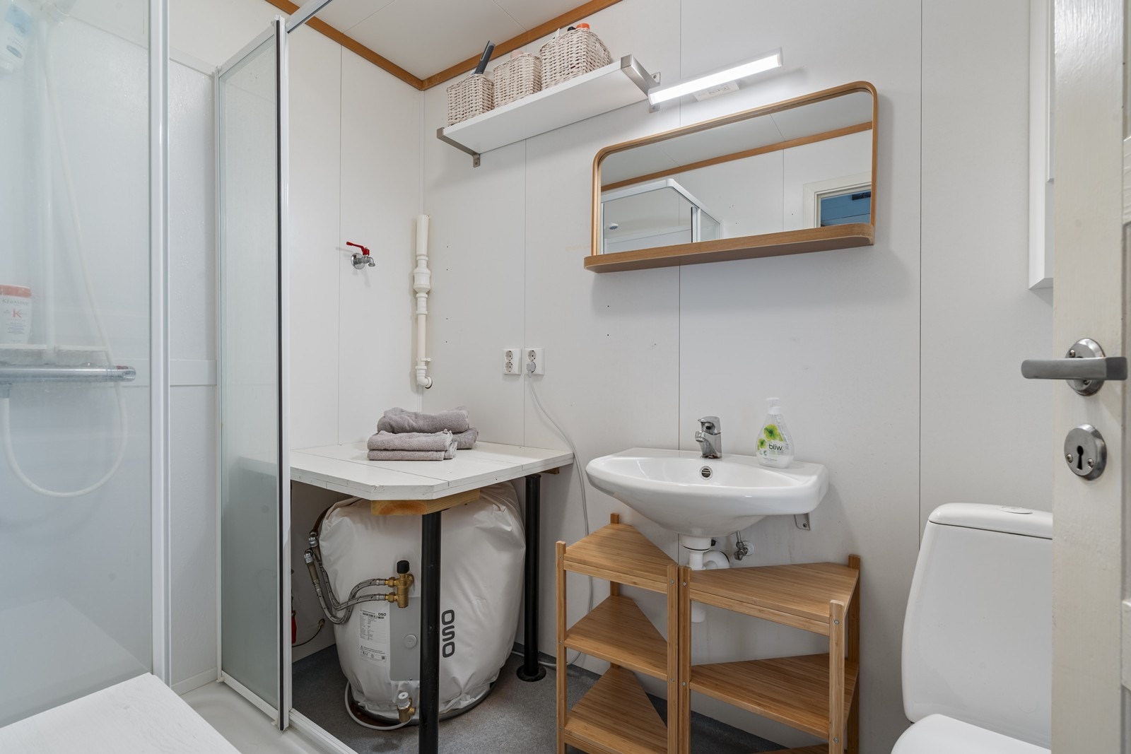 Bad/vaskerom: Det er gulvbelegg på gulv og våtromsplater på vegg. Badet har dusjkabinett, servant, toalett, varmtvannsbereder og opplegg for vaskemaskin. Varmekabler i gulv. Galleribilde