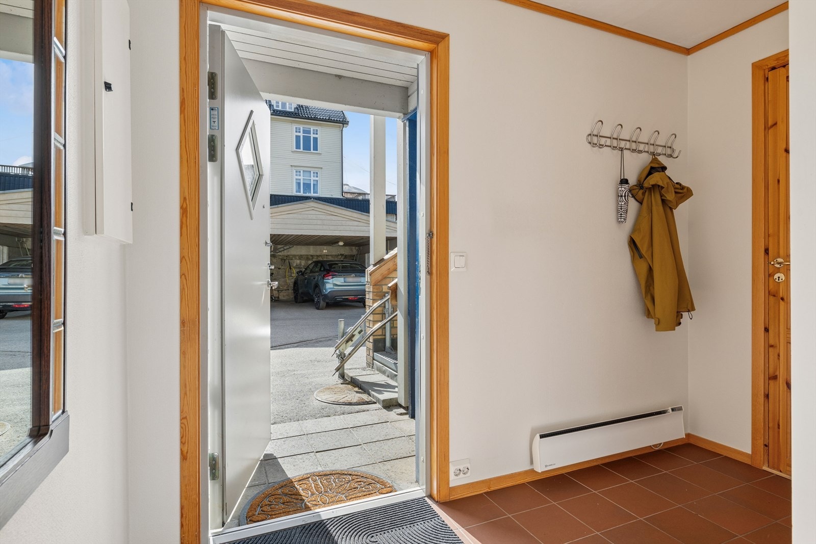 Hellelagt inngangsparti ønsker deg velkommen inn til en praktisk entré. Galleribilde