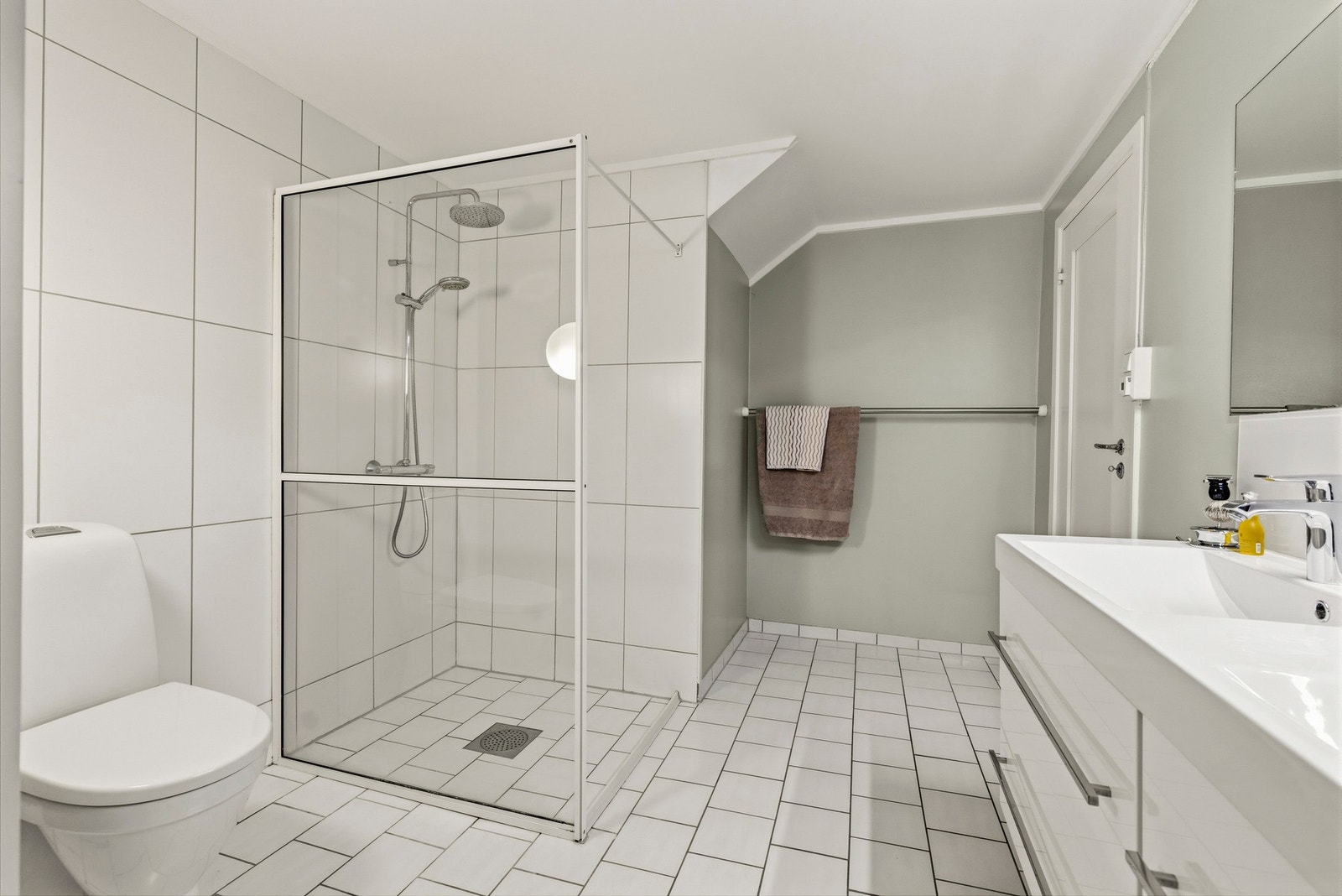 På det nederste planet (plan 1) et dette badet. Badet har flislagte gulv, og fliser og malte flater på vegger. Galleribilde