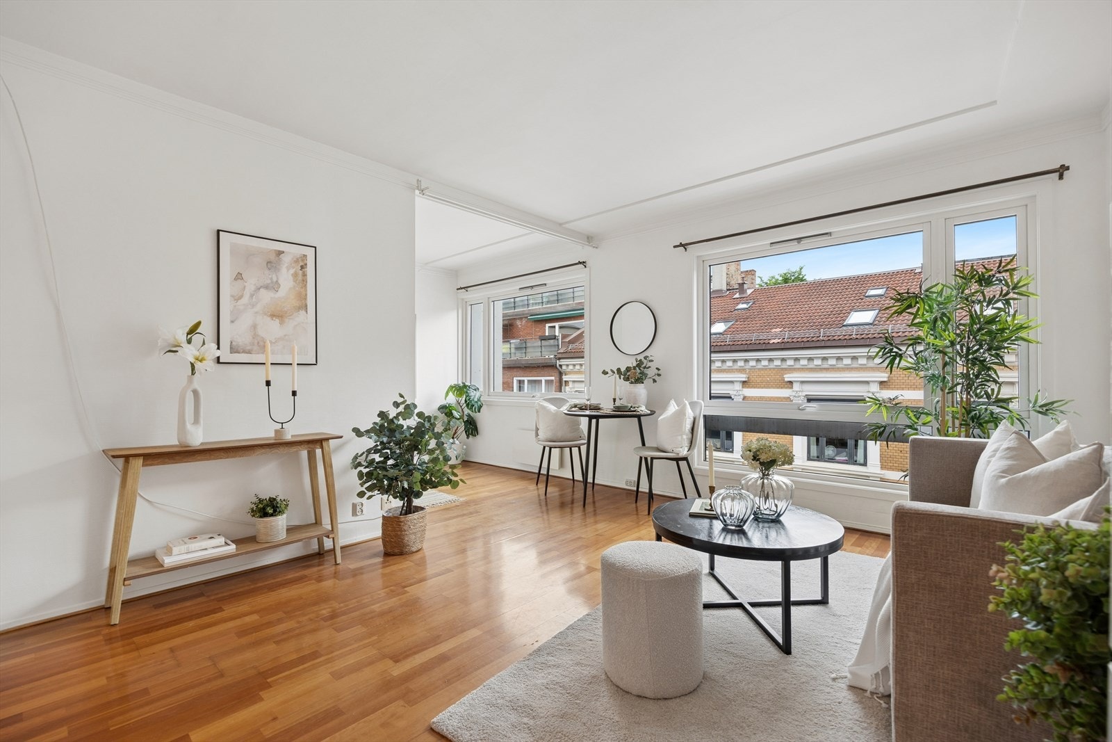 Stuen er lys og luftig med god plass til en sofa, et lite sidebord og en hyggelig konsollbord langs veggen. Fra sofaen er det fritt innsyn mot spisehjørnet og den luftige utsikten utenfor. Galleribilde