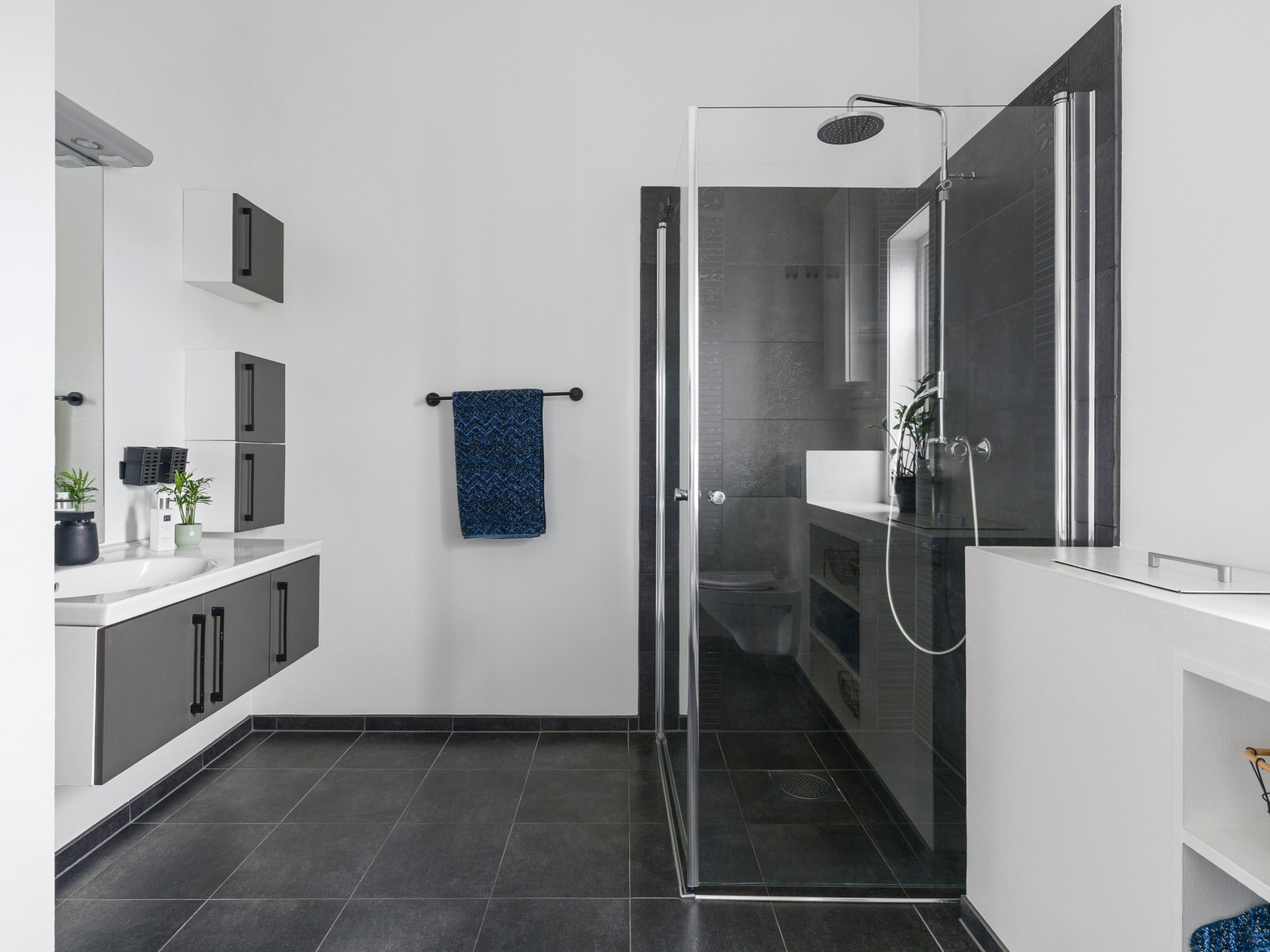 Badet har en praktisk og funksjonell utforming med flislagt gulv og fliser i dusjsonen, mens øvrige vegger er utført med malt strietapet. Galleribilde
