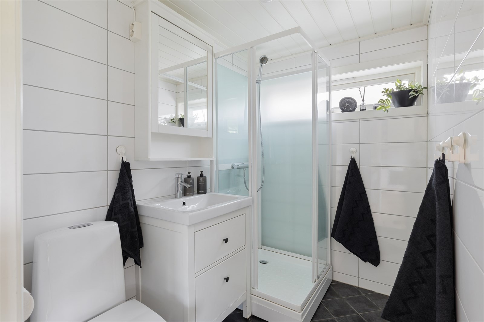 Nyere bad med hvite fliser på veggene og mørke på gulv. Det er varmekabler i gulvet. Og badet er utstyrt med toalett, servant og dusjkabinett. Separat vaskerom i underetasjen Galleribilde
