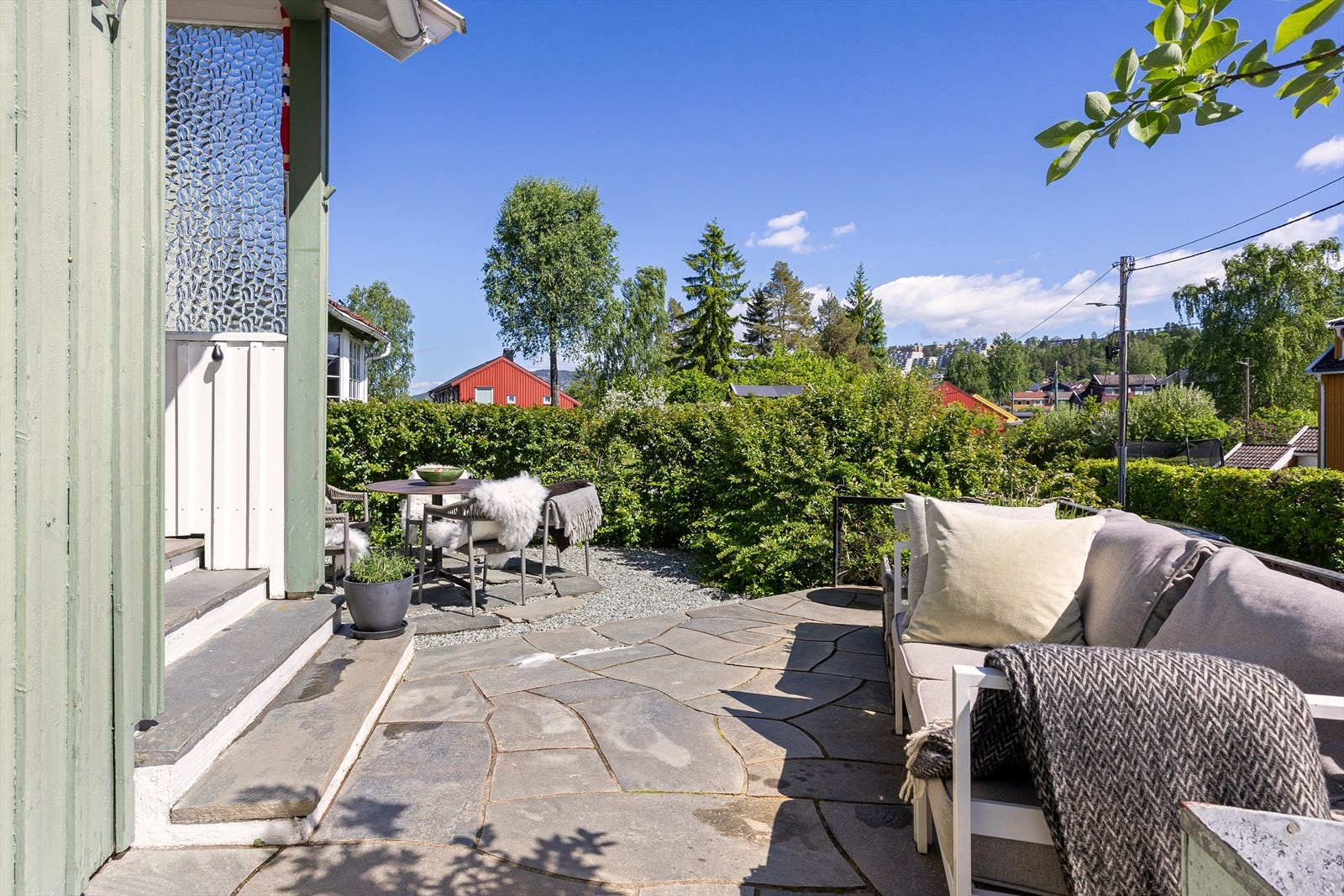 Betongtrapp med skifer i inntrinn leder opp til inngangen. Galleribilde