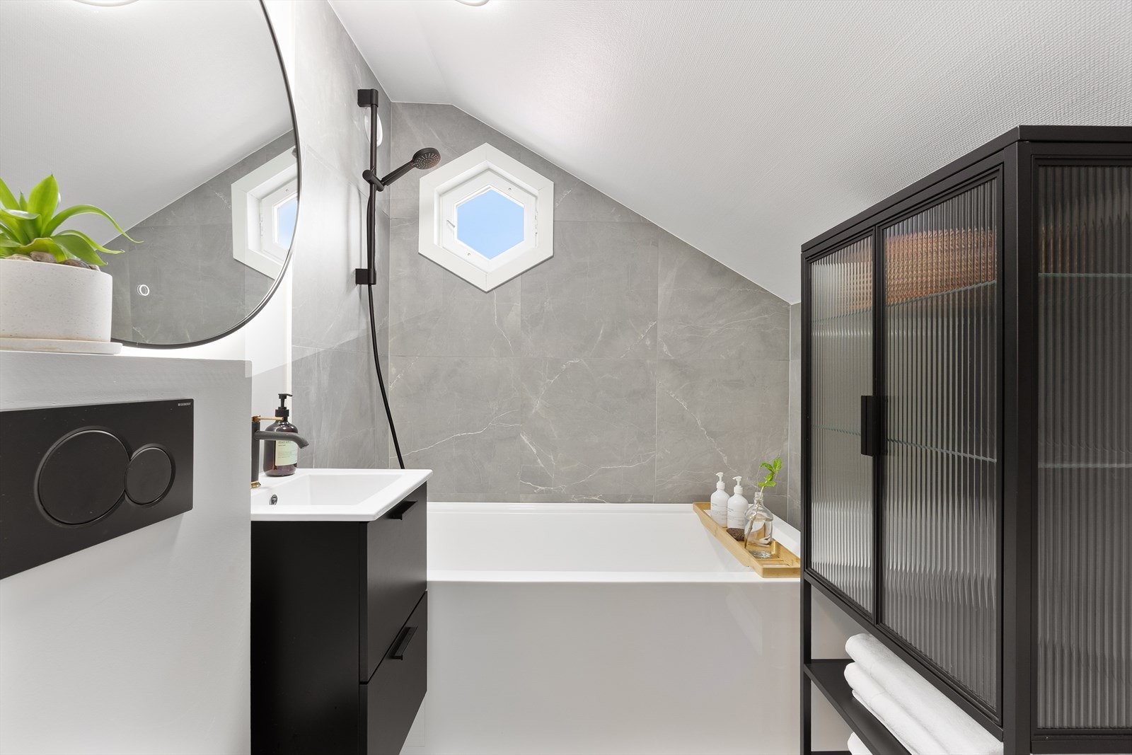 Meget lekkert bad i 2. etasje med et moderne og eksklusivt preg. Badet har varmekabler, badekar med dusjløsning, servantskap og vegghengt toalett. Galleribilde