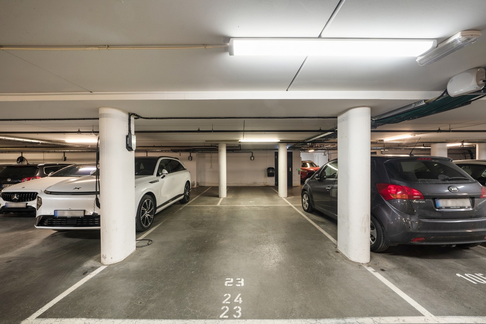 Det medfølger to garasjeplasser (ovenfor hverandre) med mulighet til å installere elbil-lader på begge plassene. Det medfølger også en bod på 5 m² i kjelleren. Heisadkomst fra kjeller til 2. etasje. Galleribilde