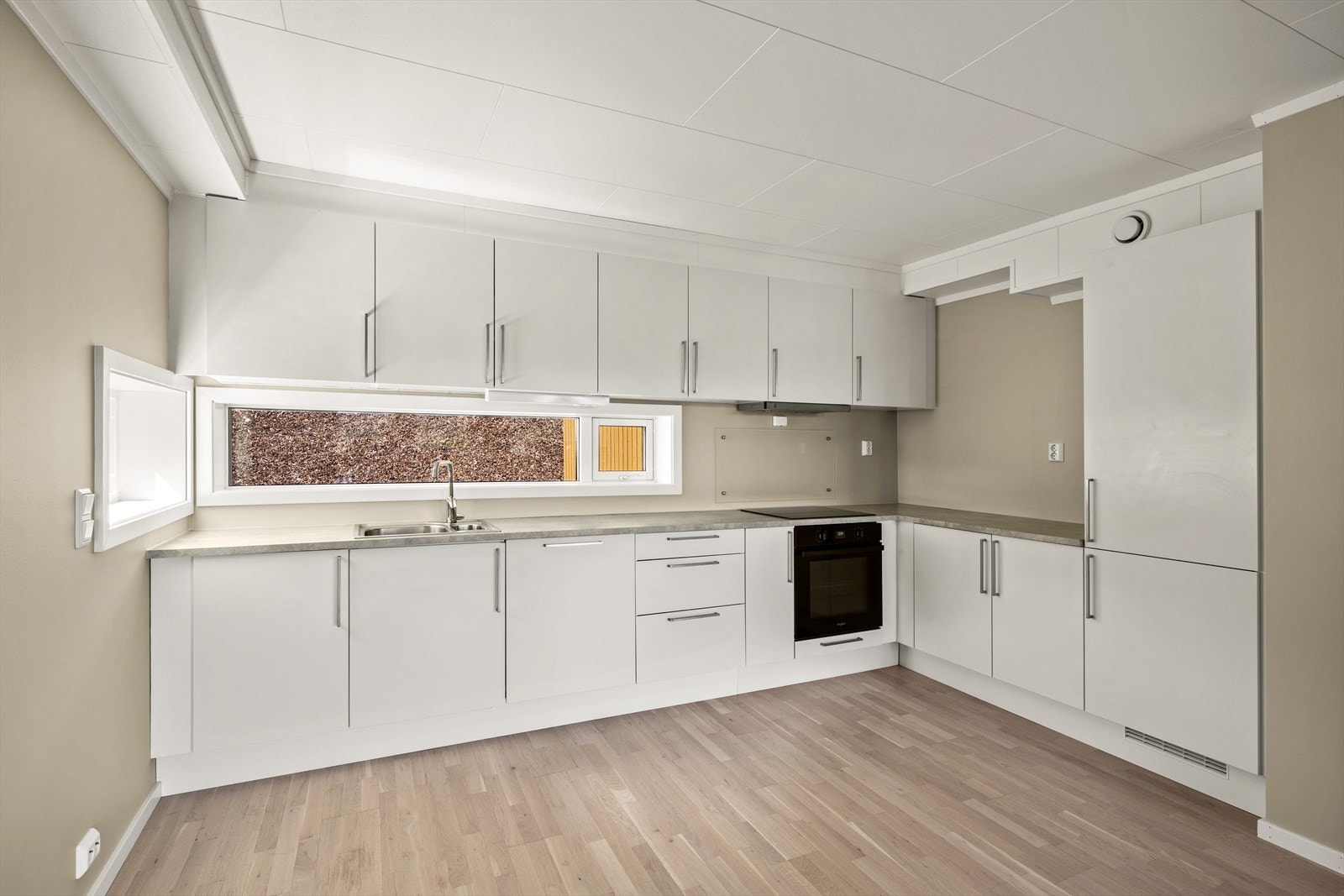 Kjøkkeninnredning med glatte fronter og benkeplate i slitesterk laminat. Galleribilde