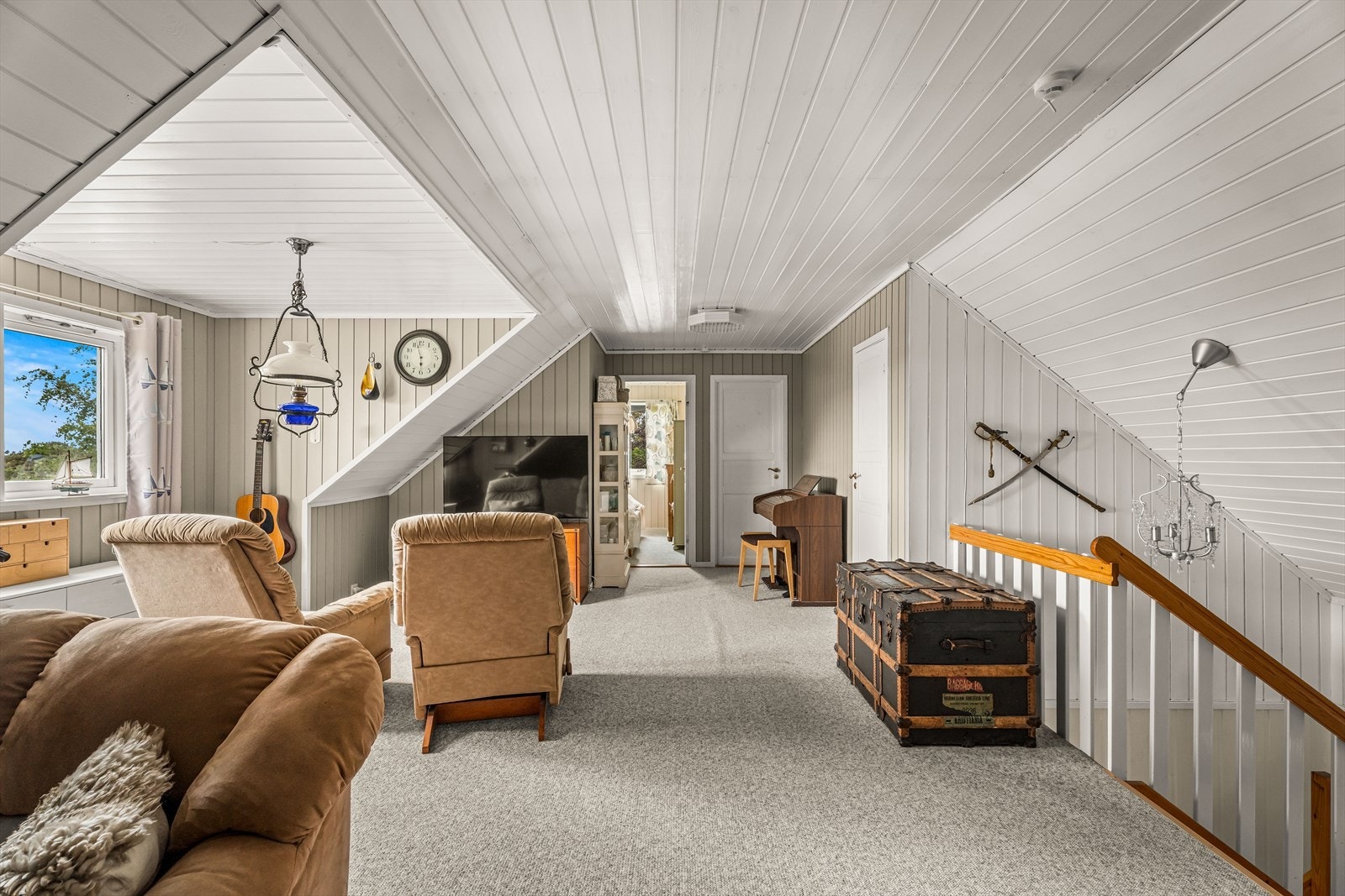 Loftstuen har teppegulv og panel på vegger og i tak. Galleribilde