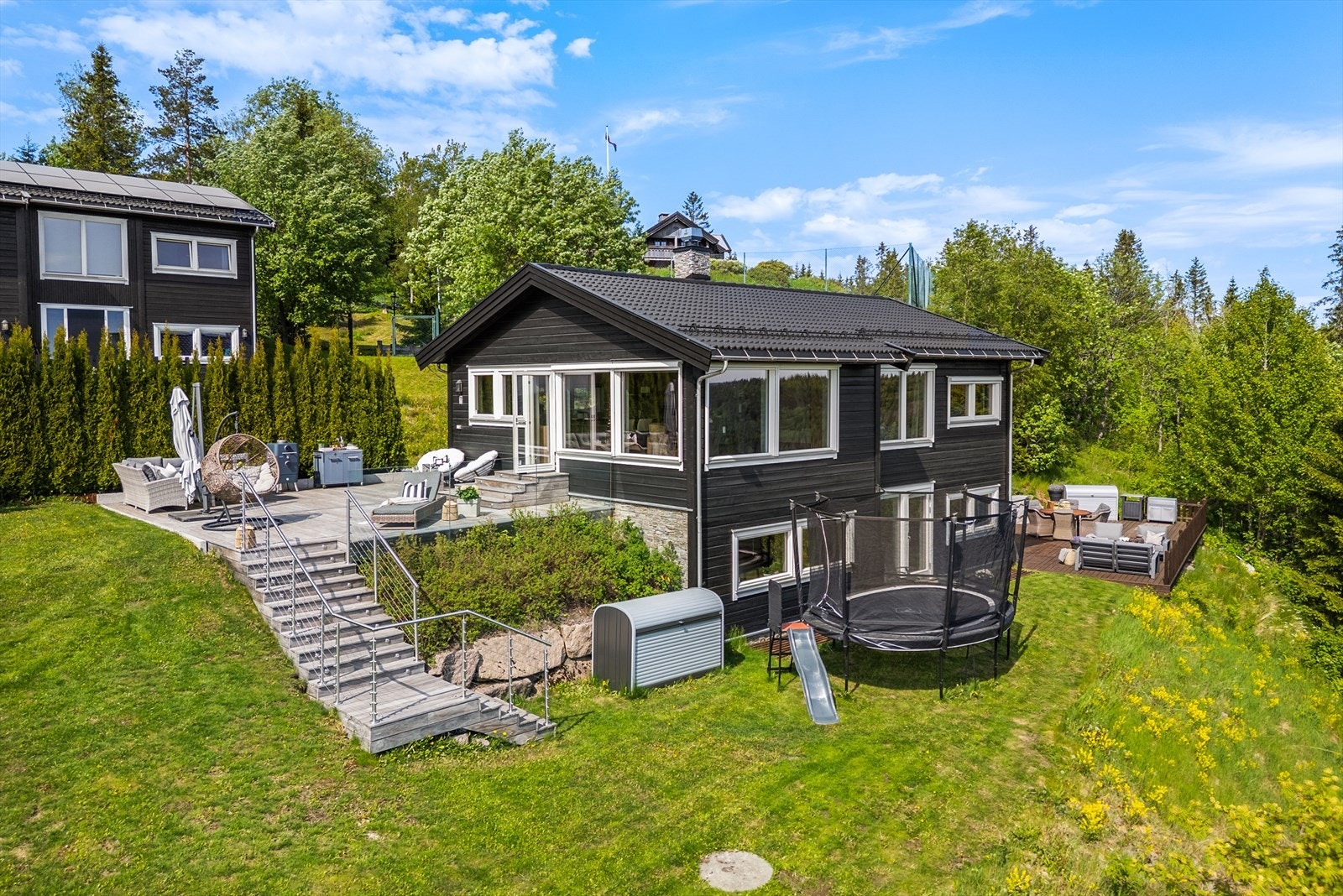 Stor, solrik tomt med flere terrasser, skjermet hage og gode soner for både lek og avslapning Galleribilde