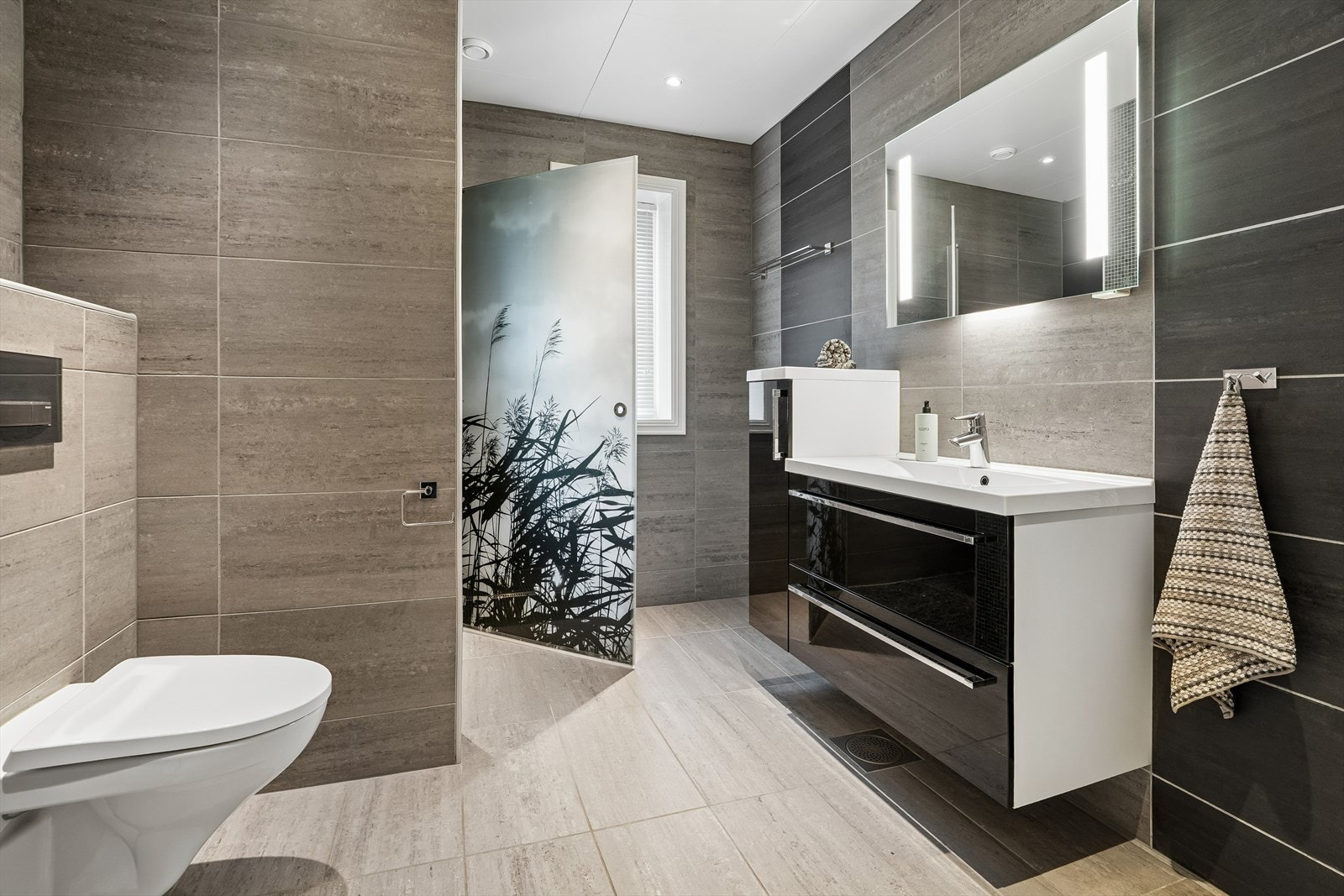 Badet i første etasje har fliser på golv og veggar, samt mosaikkfliser i dusjnisjen. Galleribilde