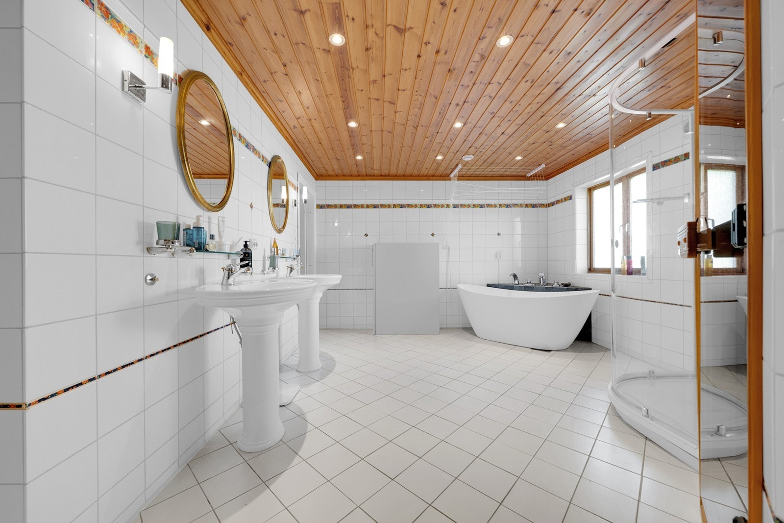 Badet er innredet med doble servanter med tilhørende speil og oppbevaringsløsninger, samt frittstående badekar. Galleribilde