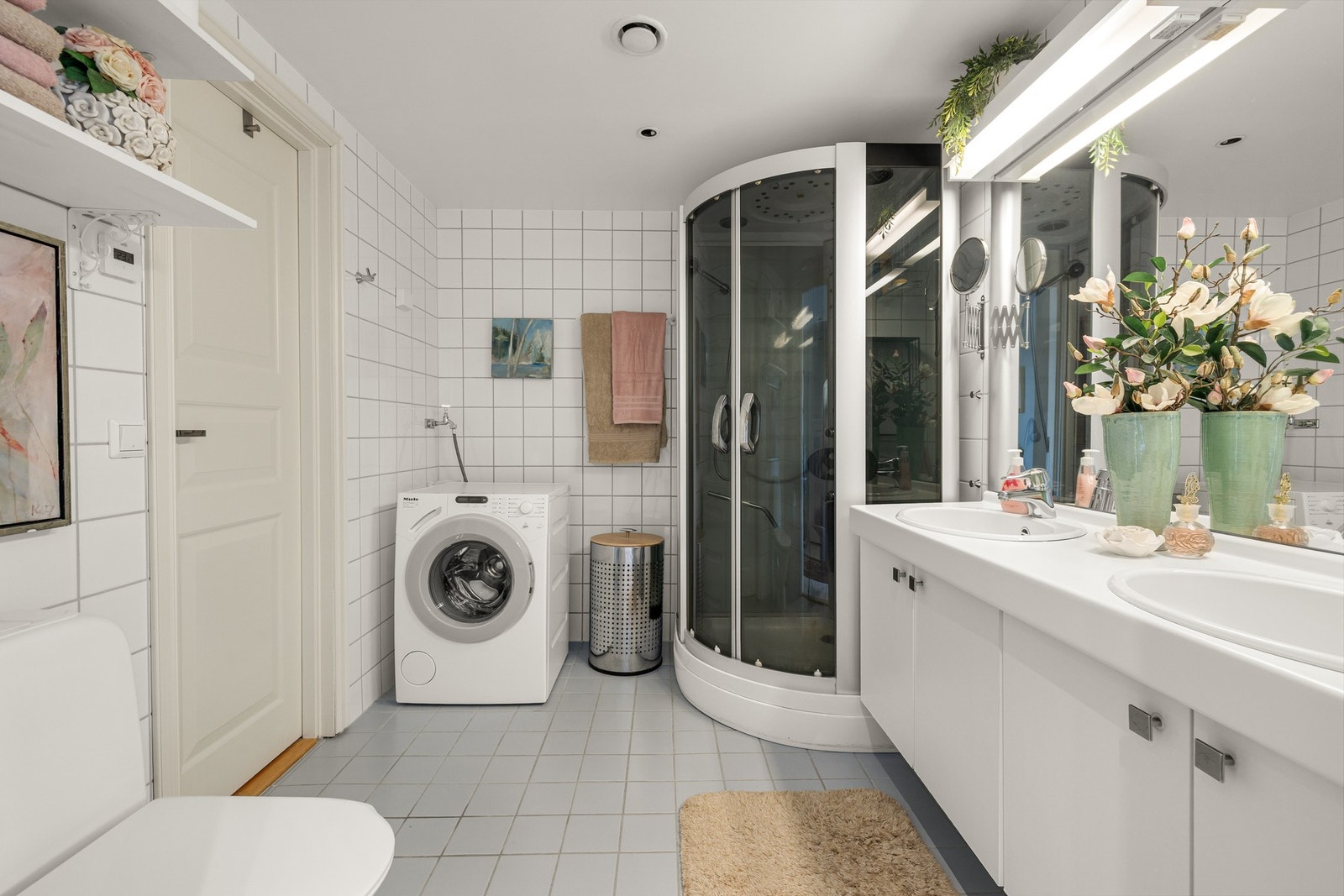 Badet er romslig og funksjonelt utformet med flislagte overflater som gir et tidløst og praktisk uttrykk. Galleribilde