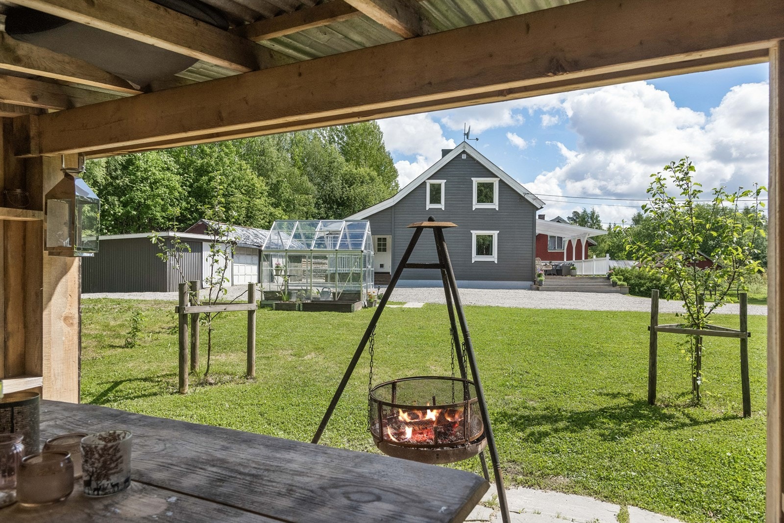Utsikt fra gapahuken mot hovedhuset, drivhuset og garasjen. Galleribilde