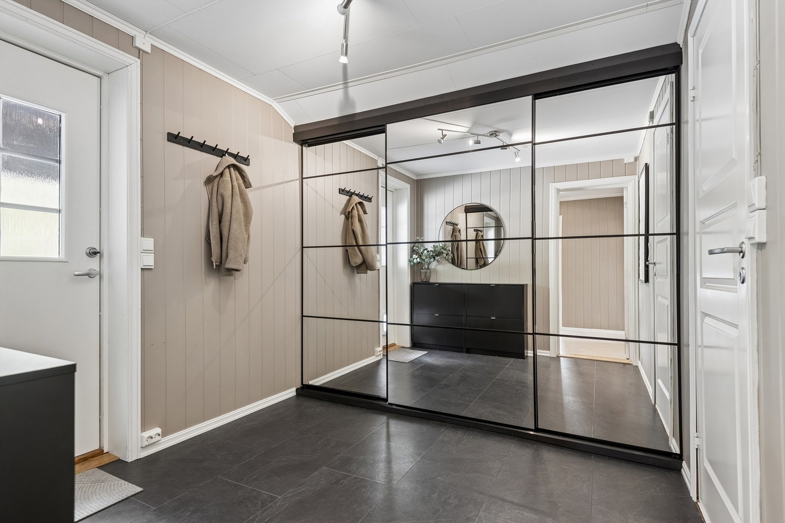 En romslig skyvedørsgarderobe med speilfronter gir gode oppbevaringsmuligheter i entréen, som er meget romslig! Galleribilde