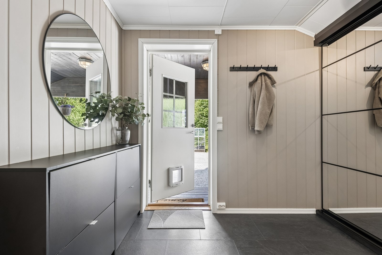 Entréen har malte panelvegger og laminat på gulvet. Galleribilde