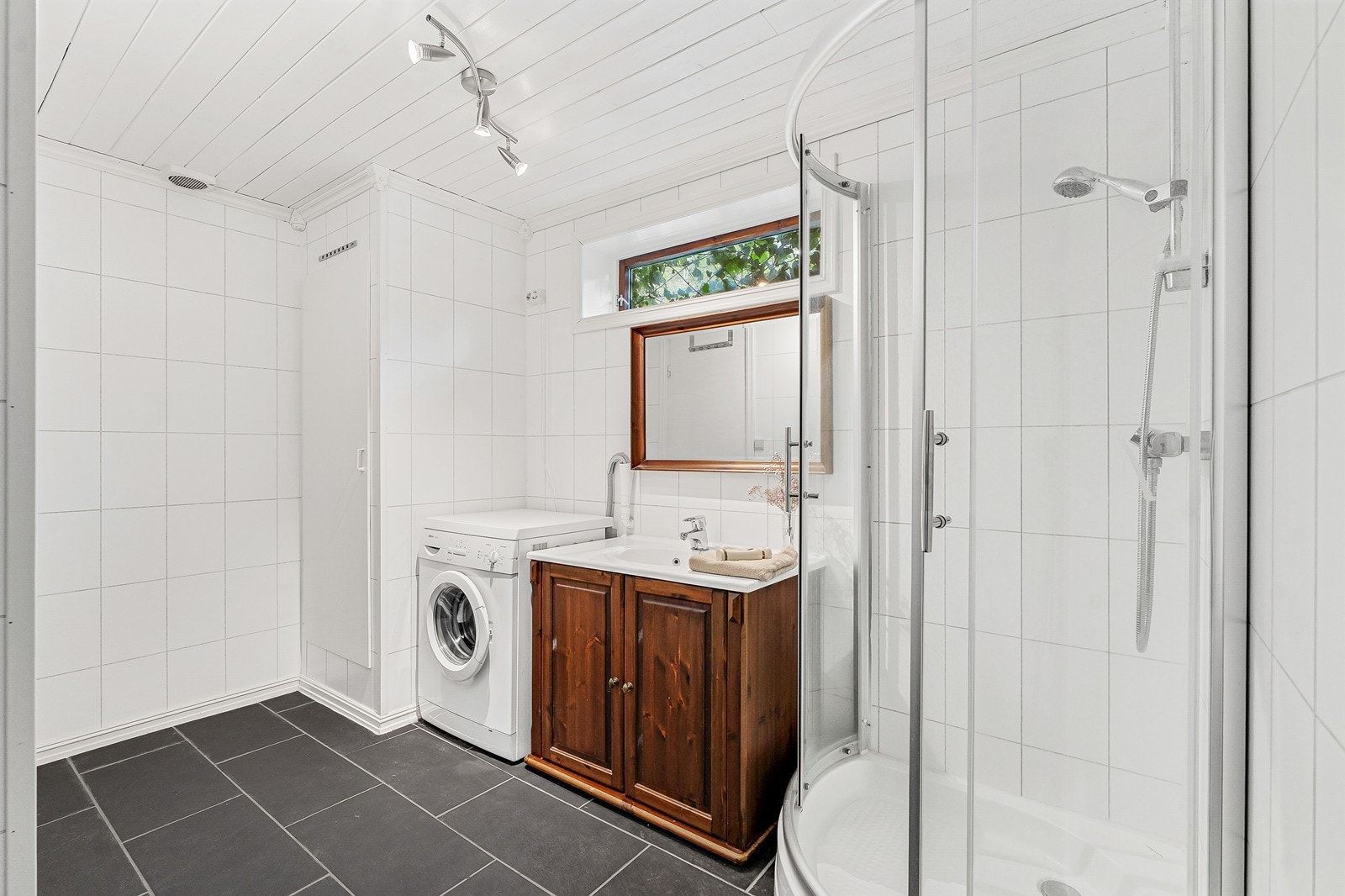 Badet er av god størrelse og er innredet med dusj, baderomsinnredning og opplegg for vaskemaskin. Galleribilde