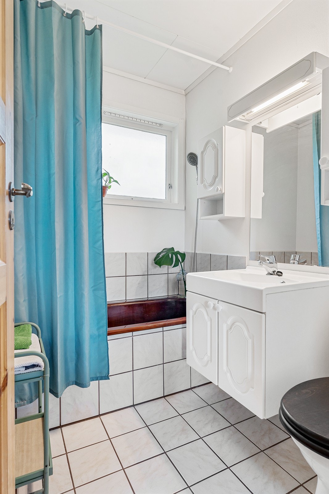 Badet er av god størrelse og er innredet med innebygd badekar, gulvmontert toalett samt servant med skap og speil. Galleribilde