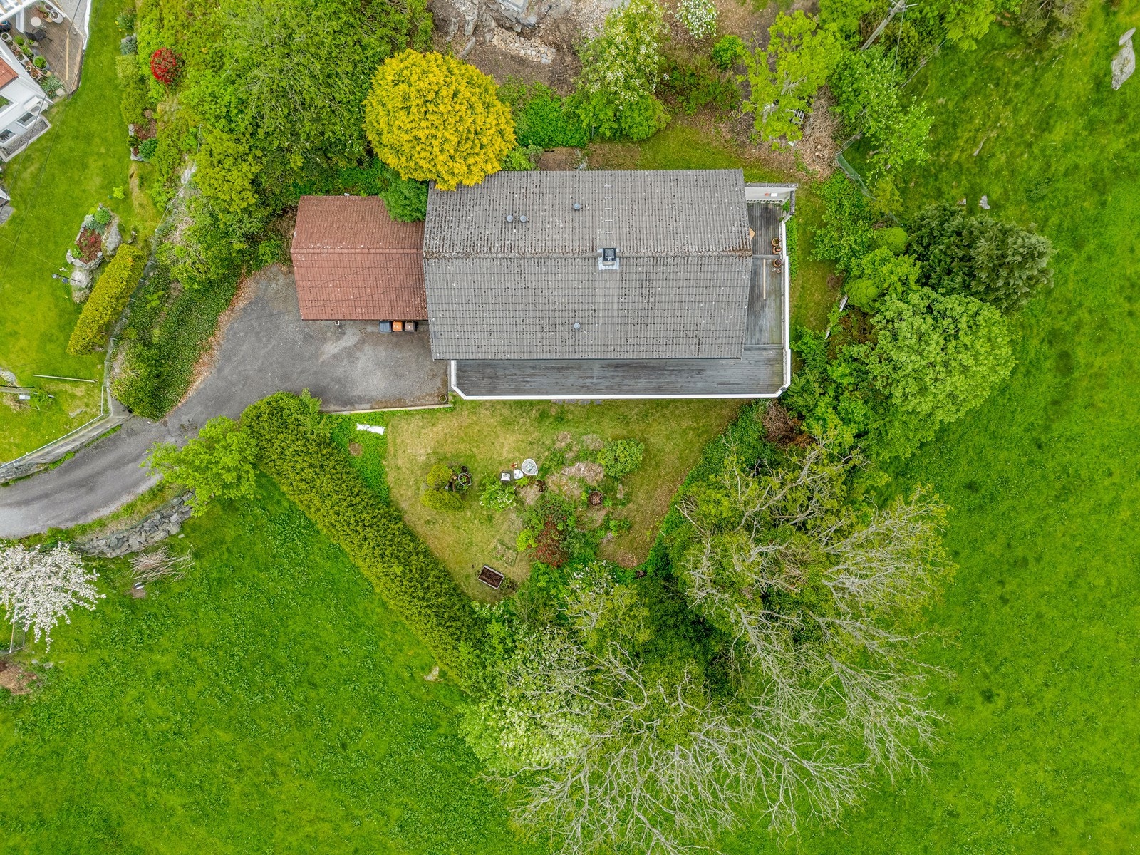 Tomten er pent opparbeidet og fremstår som velholdt, med en fin kombinasjon av hagearealer, plen og beplantning. Galleribilde