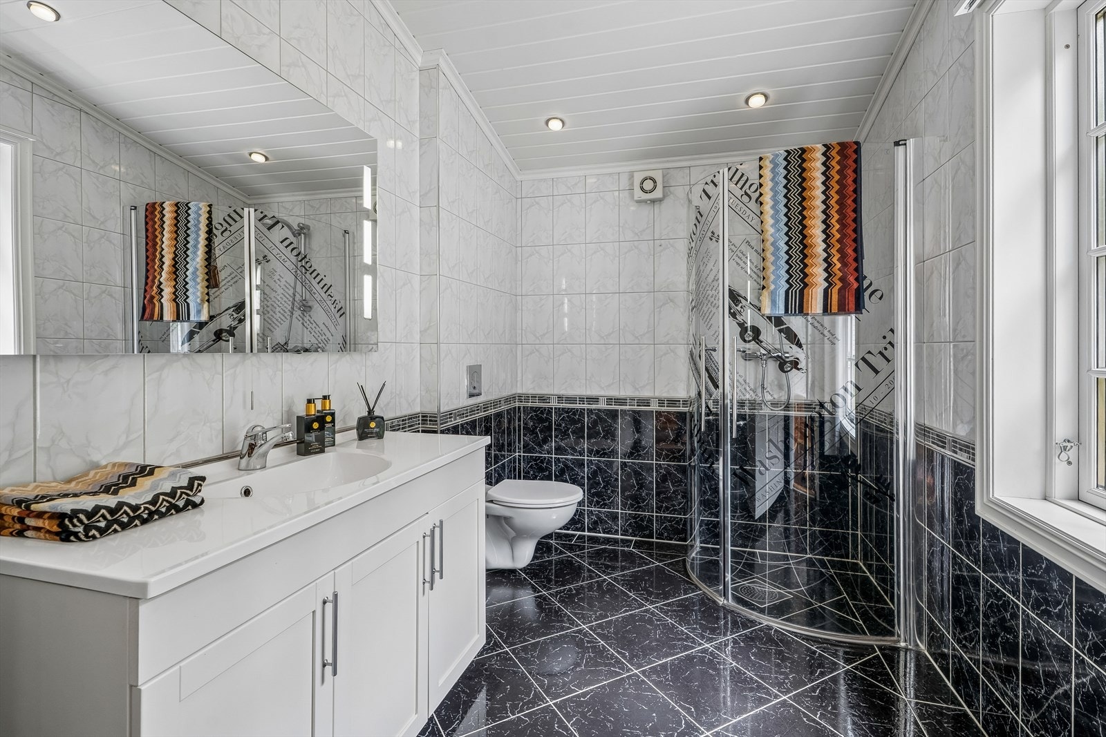 Badet frå 2012 har flislagt golv med varmekablar, veggmontert klosett og dusj med hengsla glasdører. Galleribilde