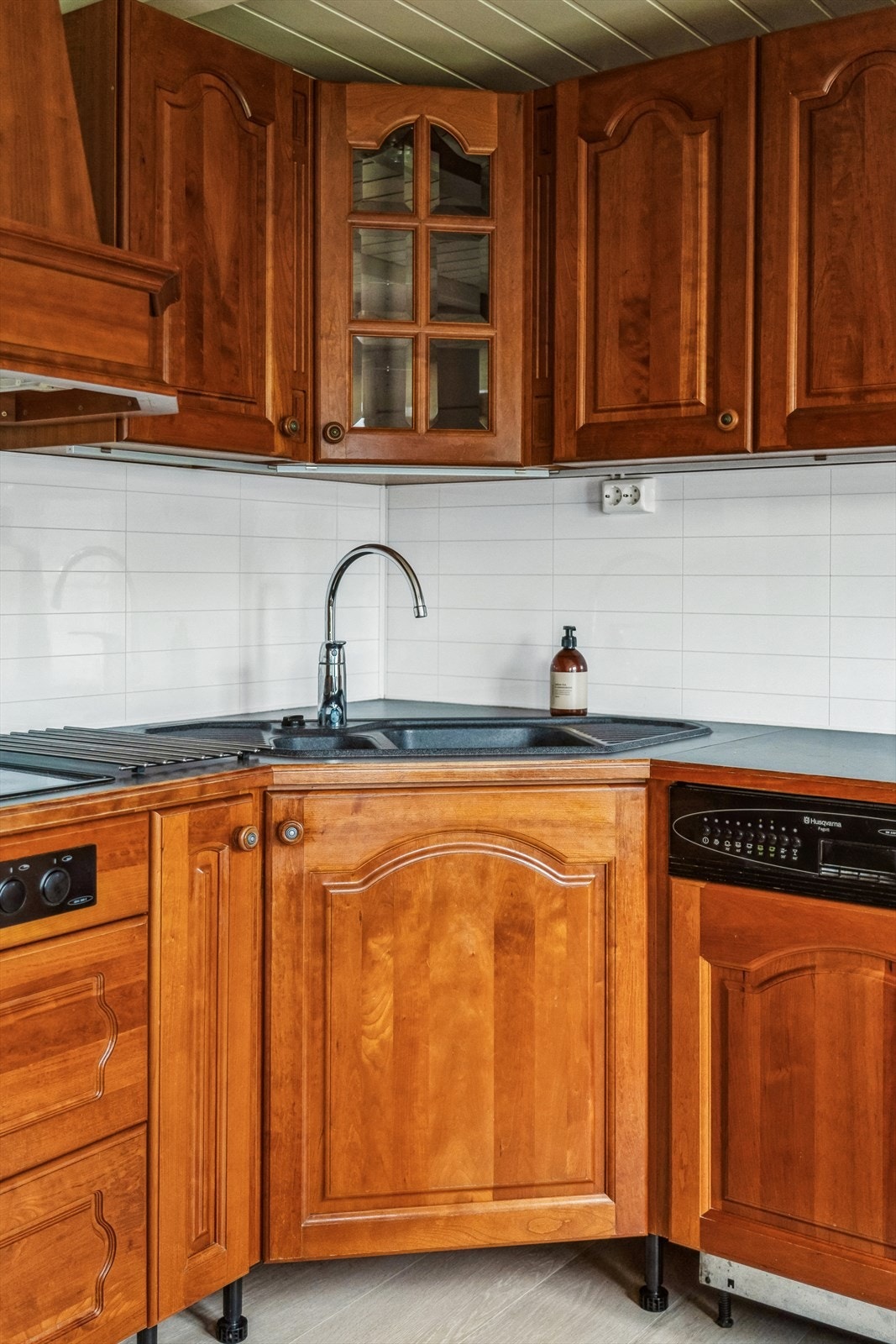 Kitchenwall-plater over benken og mekanisk avtrekk med ventilator over steikesona. Galleribilde