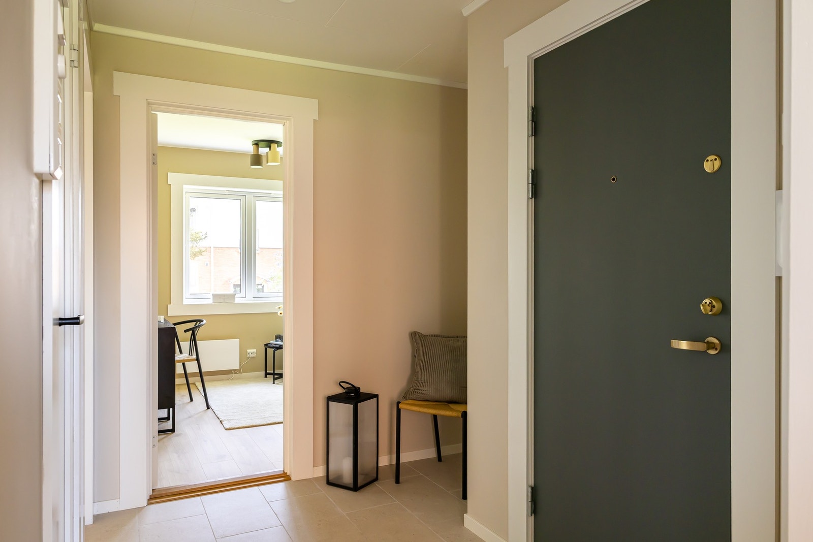 Entréen fungerer som et praktisk fordelingspunkt i boligen, med adkomst videre til kjøkken, bad, stue og et av leilighetens to soverom. Galleribilde