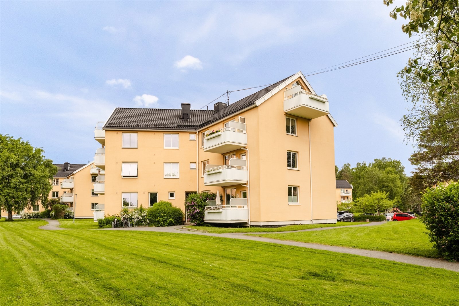 Det er store grøntarealer rundt blokkene, og fellesområdene er pent opparbeidet med gressplen, beplantning, sittegrupper, grillplass og lekeapparater Galleribilde