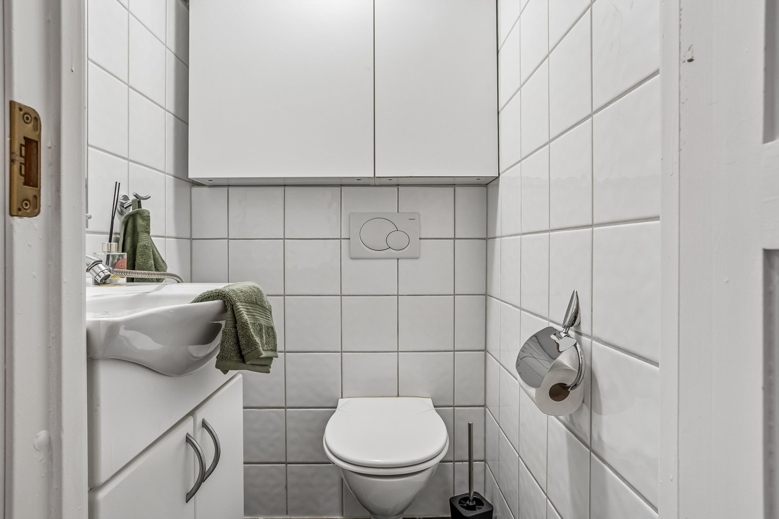Leiligheten har eget wc-rom med vegghengt toalett med innebygget sisterne og en helstøpt servant med skap. Galleribilde