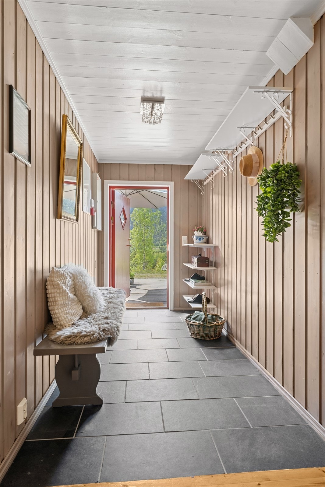 Innenfor døren til leiligheten blir du møtt av en romslig entré/gang med fliser på gulvet og lysmalte vegger. Galleribilde