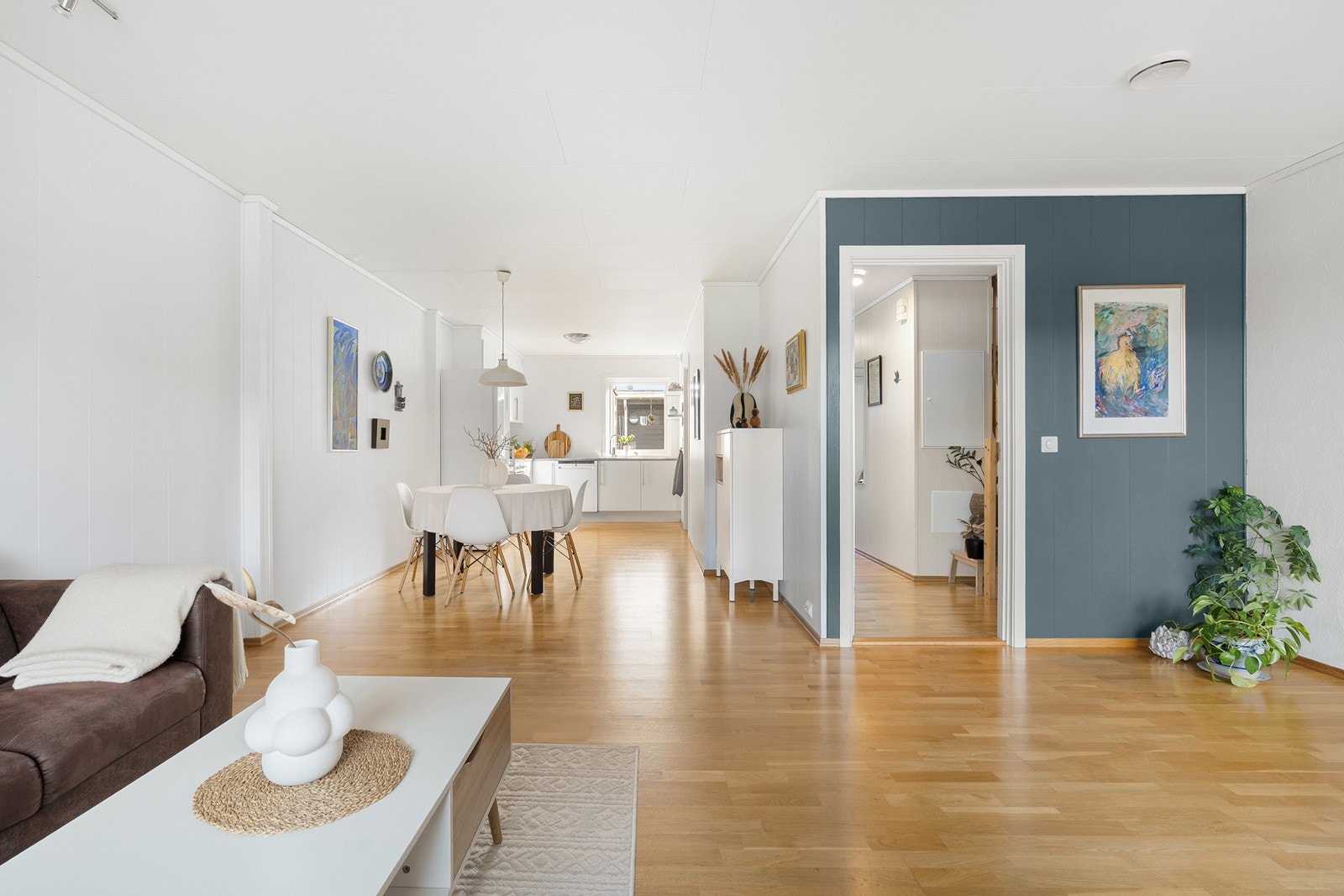 Stuen har en trivelig og naturlig avskjerming fra kjøkkenet med plass til en god sofaseksjon, sofabord og tv-benk. Galleribilde