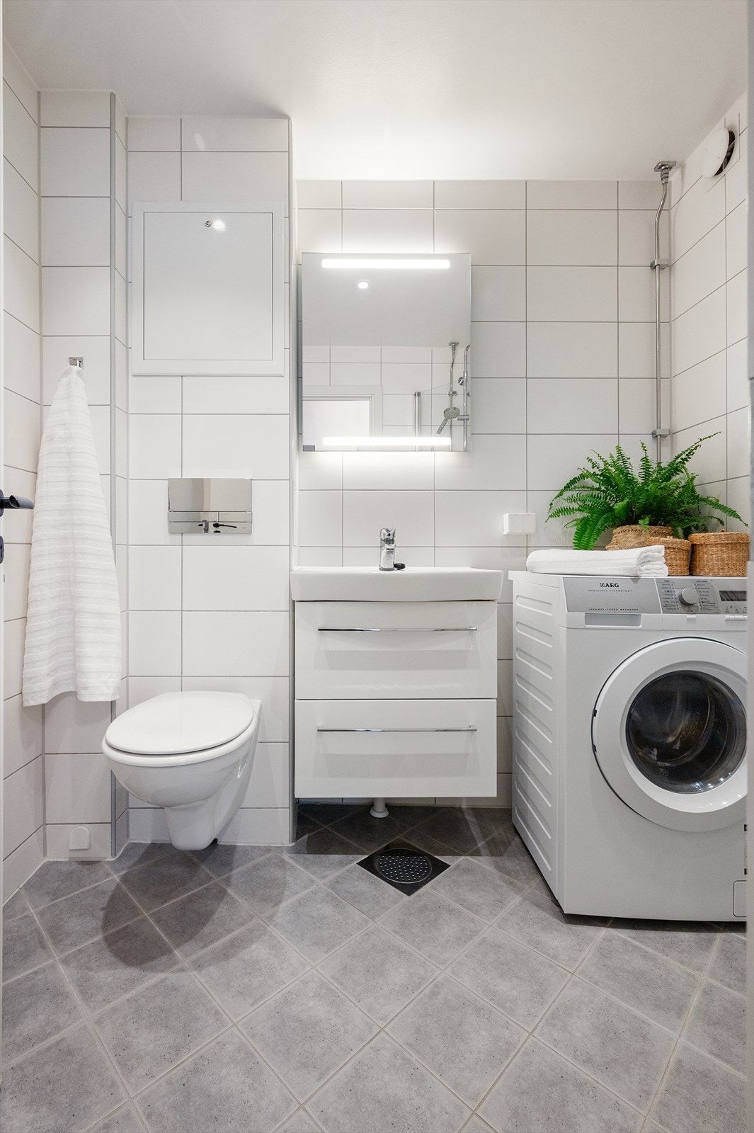 Det er opplegg for vaskemaskin. Badet har flislagt gulv med elektrisk gulvvarme, flislagte vegger og malt himling med downlights. Naturlig avtrekk. Galleribilde