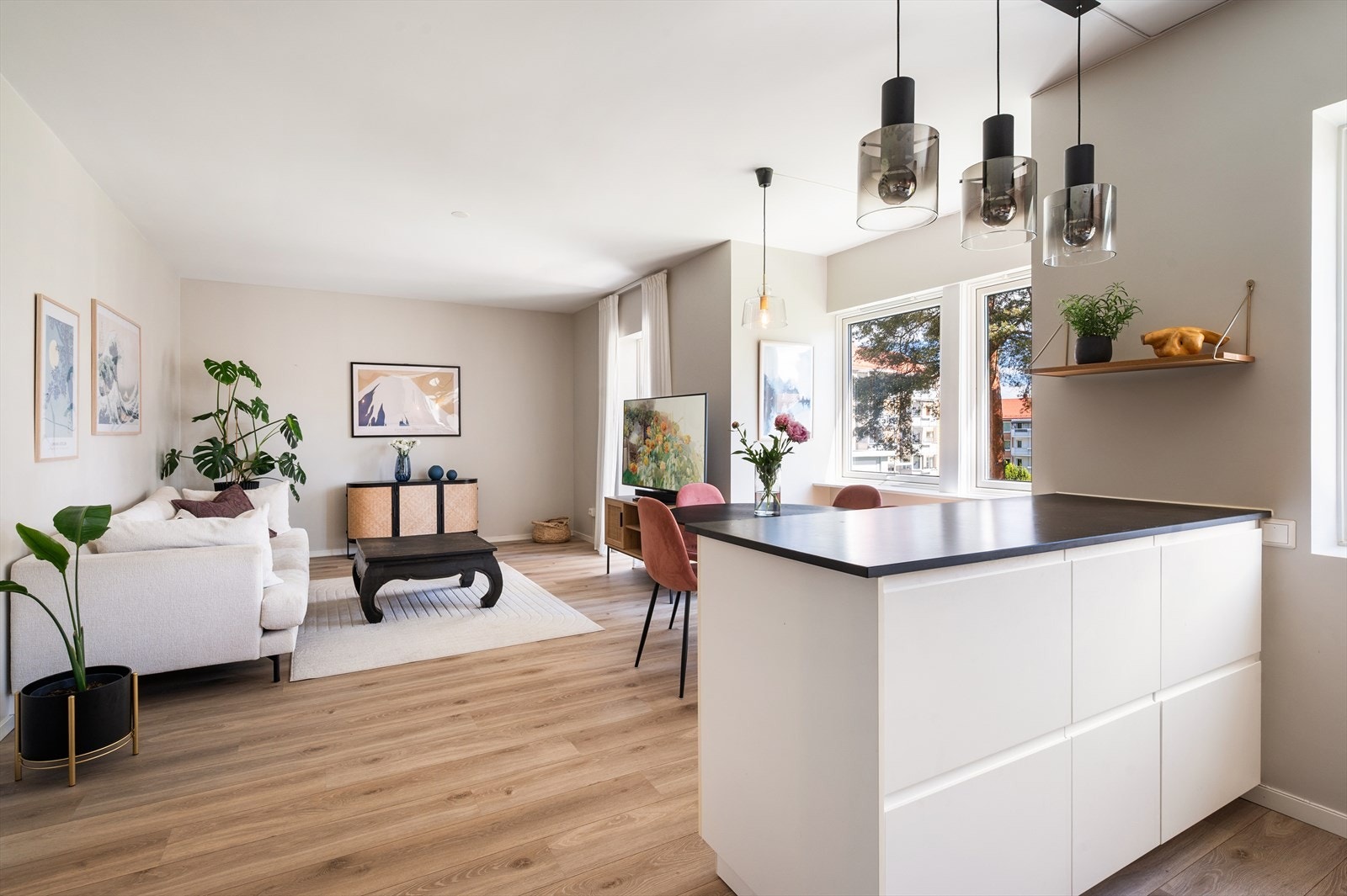 Stue- og kjøkken er malt i moderne, lyse fargetoner og en-stavs laminat på gulv. Galleribilde