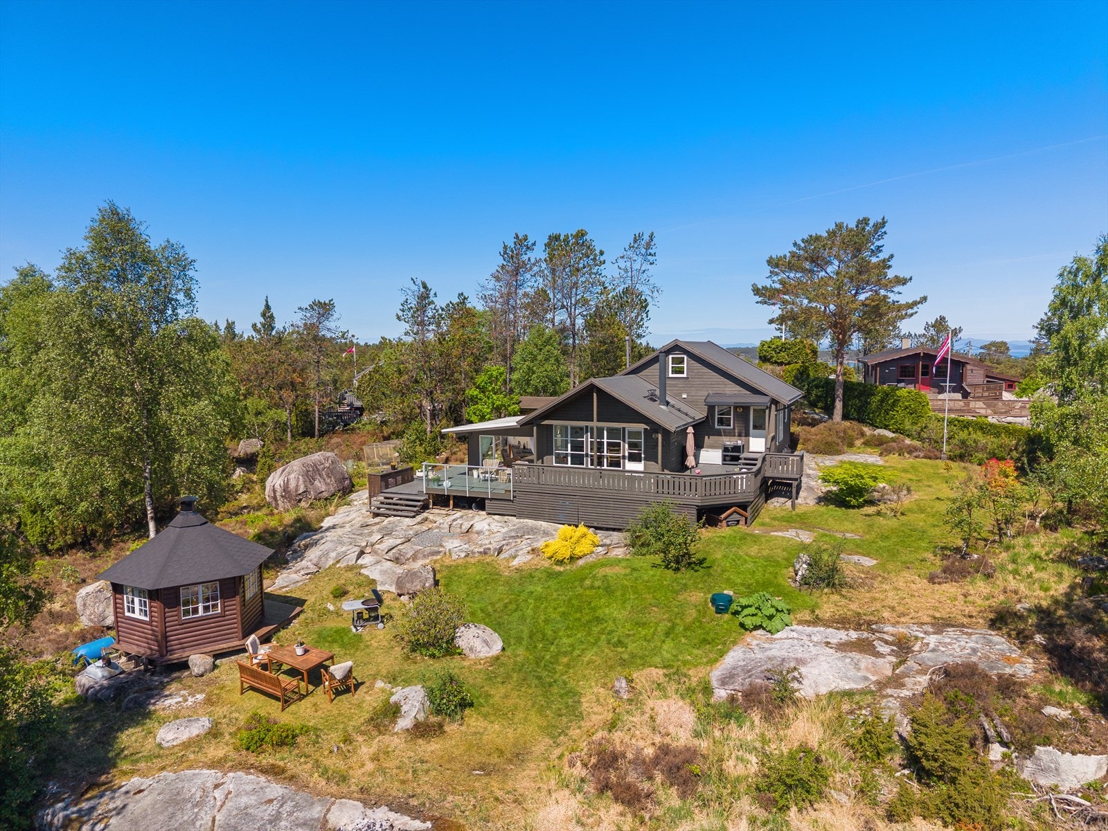 Hytta sett i sammenheng med den romslige naturtomten. Galleribilde