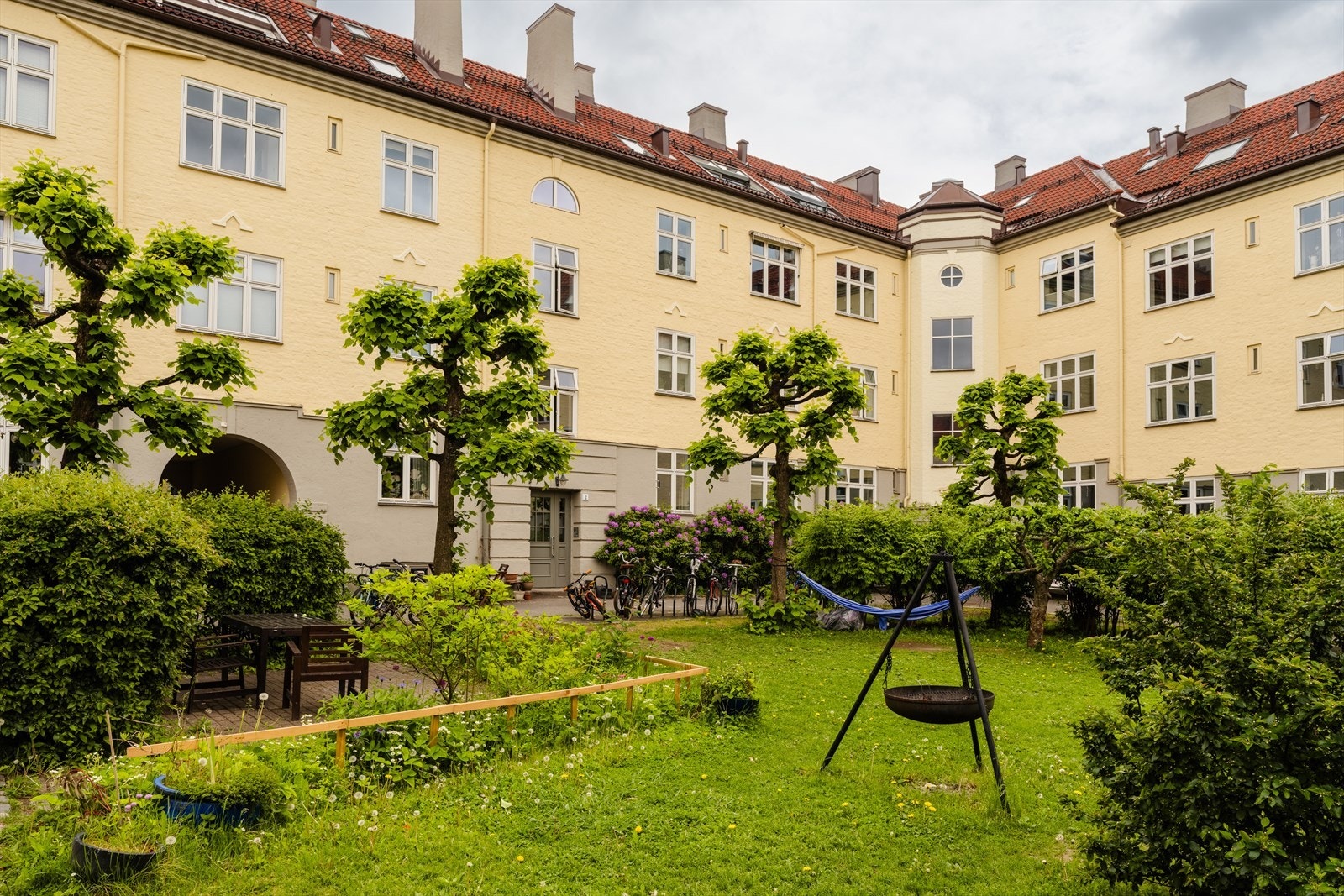 Boretslaget - Lirekassa har en nydelig lukket bakgård. Her er det flere sitteplasser, grill, bålpanne, busker, plen og trær. Bakgården oppleves som en egen park/hage for beboerne i borettslaget. Galleribilde