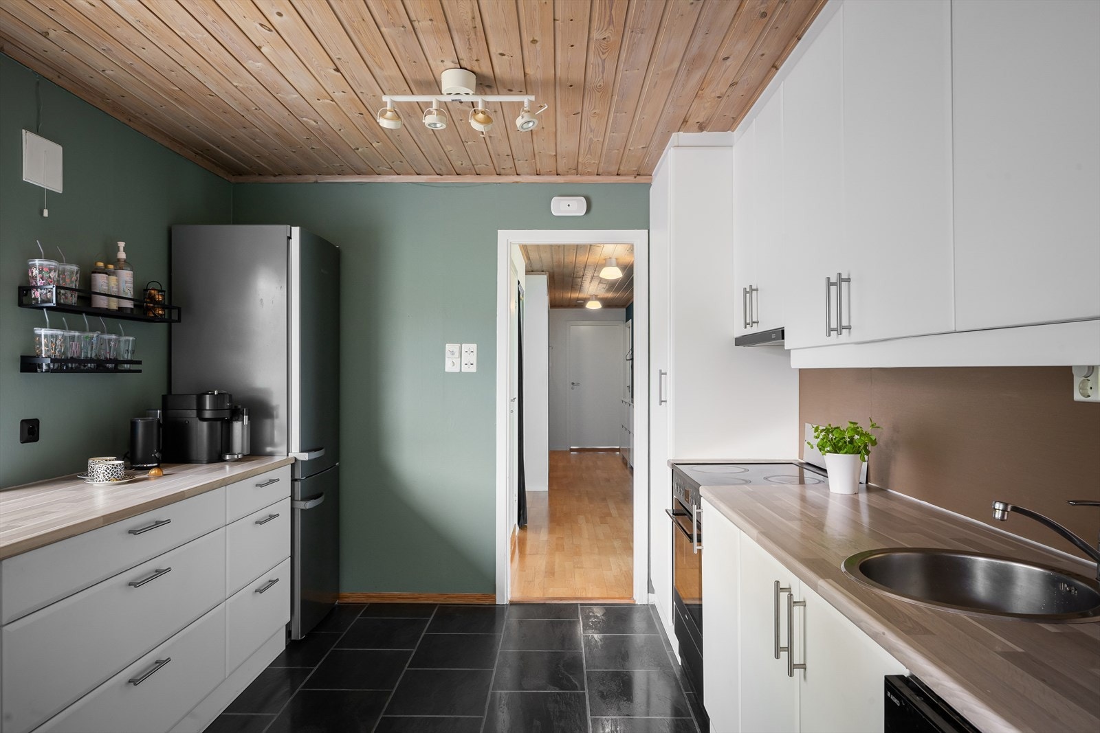 Kjøkkenet i hoveddelen har innredning med glatte fronter og benkeplate i laminat. Galleribilde
