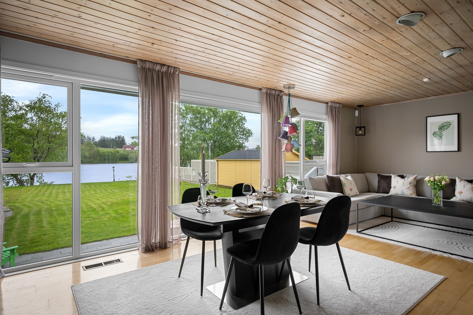 Spisestuen har plass til langbord og er rammet inn av store vindusflater mot hagen og vannet. Galleribilde