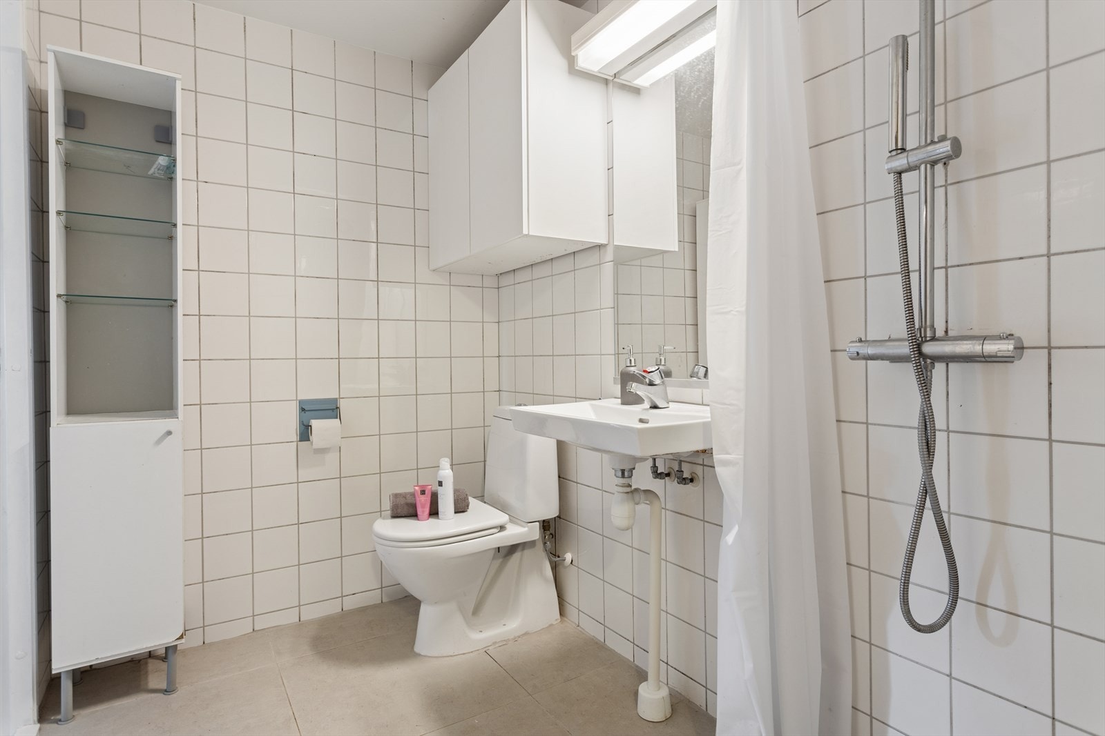 Videre har badet dusj med forheng, termostatstyrt blandebatteri og gulvstående toalett. Galleribilde