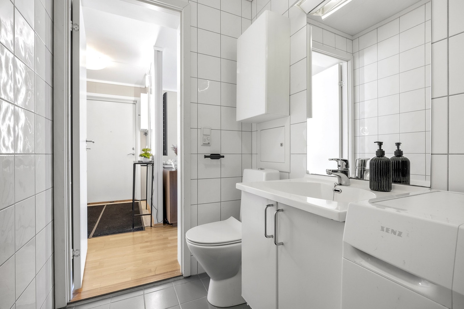 Badet er innredet med vegghengt servant, speil med overlys og gulvstående toalett. Galleribilde