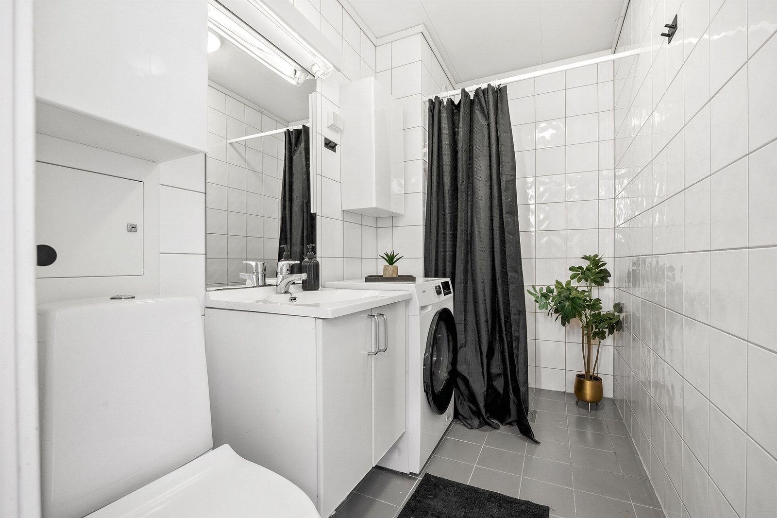 Flislagt bad med gulvvarme og opplegg for vaskemaskin. Galleribilde