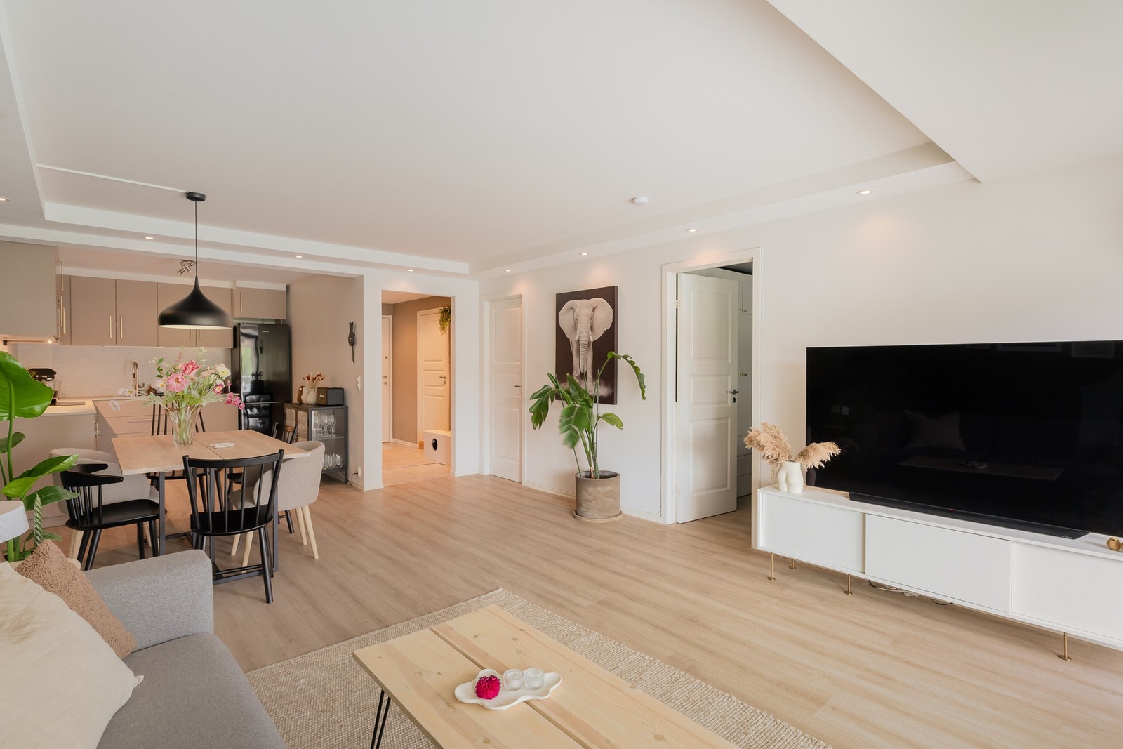 Lys og luftig stue med store, heldekkende vindusflater som slipper inn rikelig med naturlig dagslys, énstavs laminat på gulv, downlights i himling og moderne fargevalg på vegger. Galleribilde