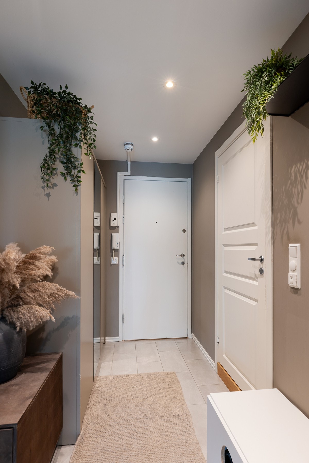 Innbydende og praktisk entré med lyse gulvfliser og downlights i himling. I entréen er det god plass til oppbevaring av sko og yttertøy i medfølgende garderobeskap med speilfront. Galleribilde