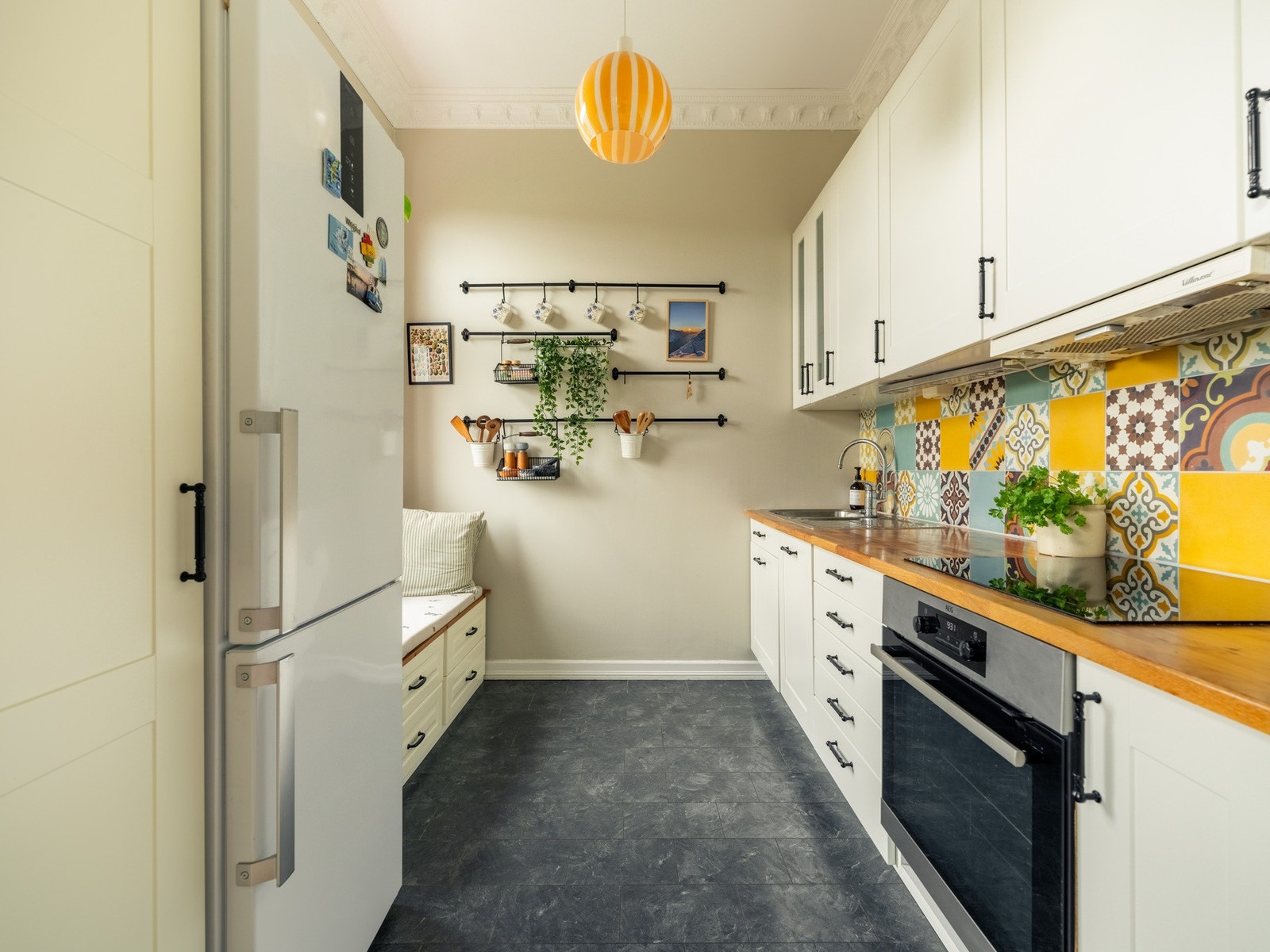 Kjøkkenet har et tidløst uttrykk med en moderne innredning bestående av slette og profilerte fronter, benkeplate av heltre, integrerte hvitevarer og egen plass til frittstående kjøleskap. Galleribilde